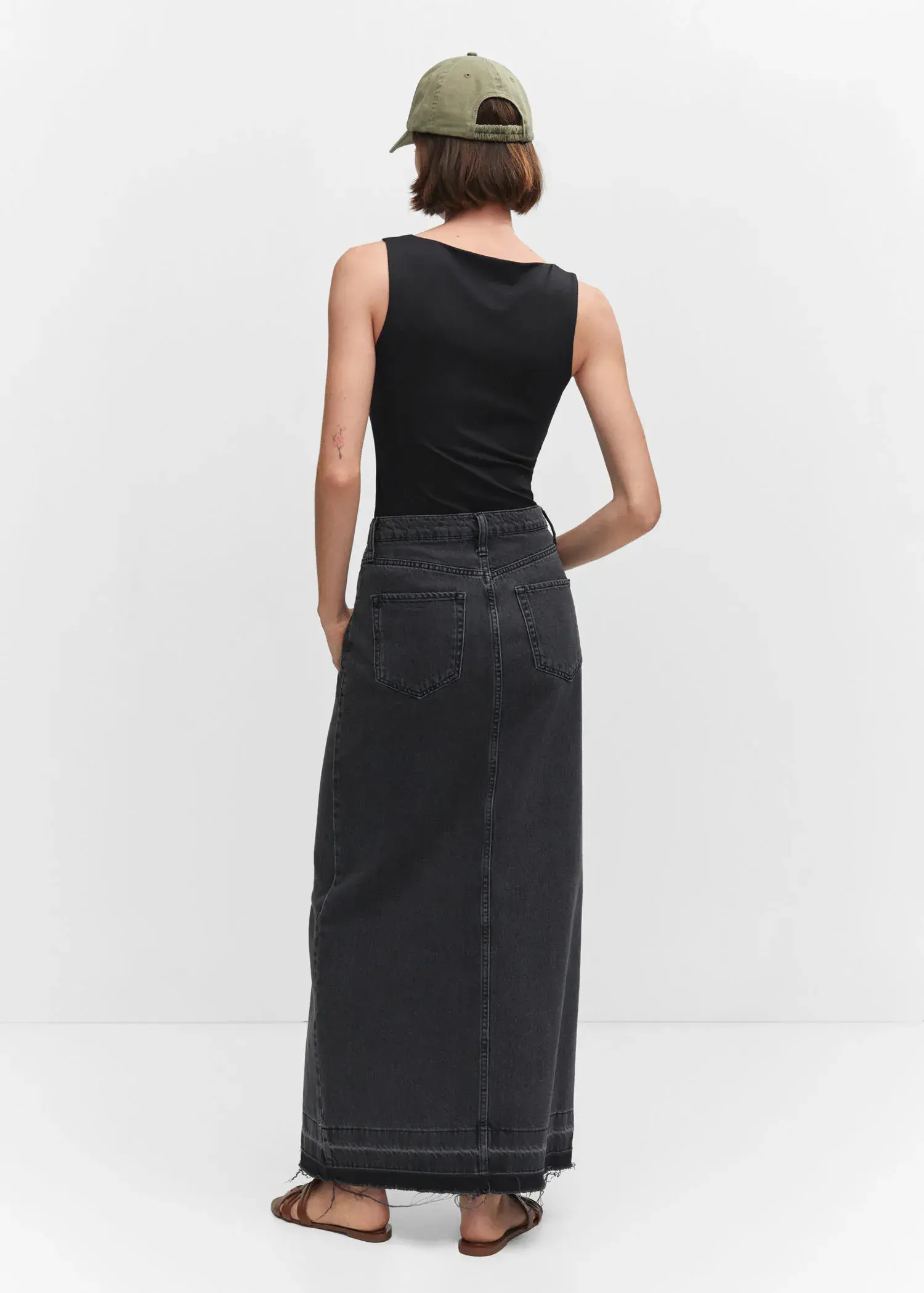 Mango Open elastic top. a woman wearing a black tank top and a long black skirt. 