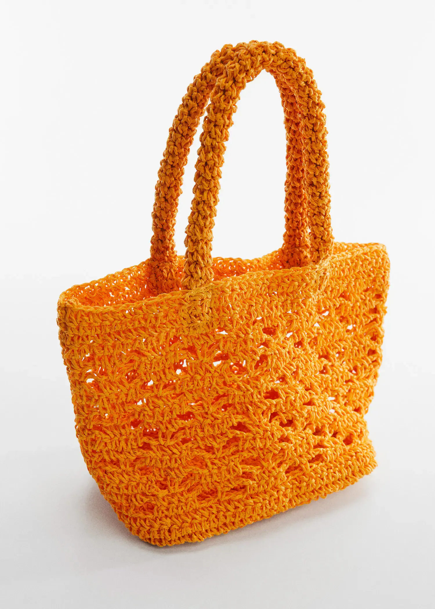 Mango Double-handle raffia bag. an orange crocheted bag with handles on a table. 