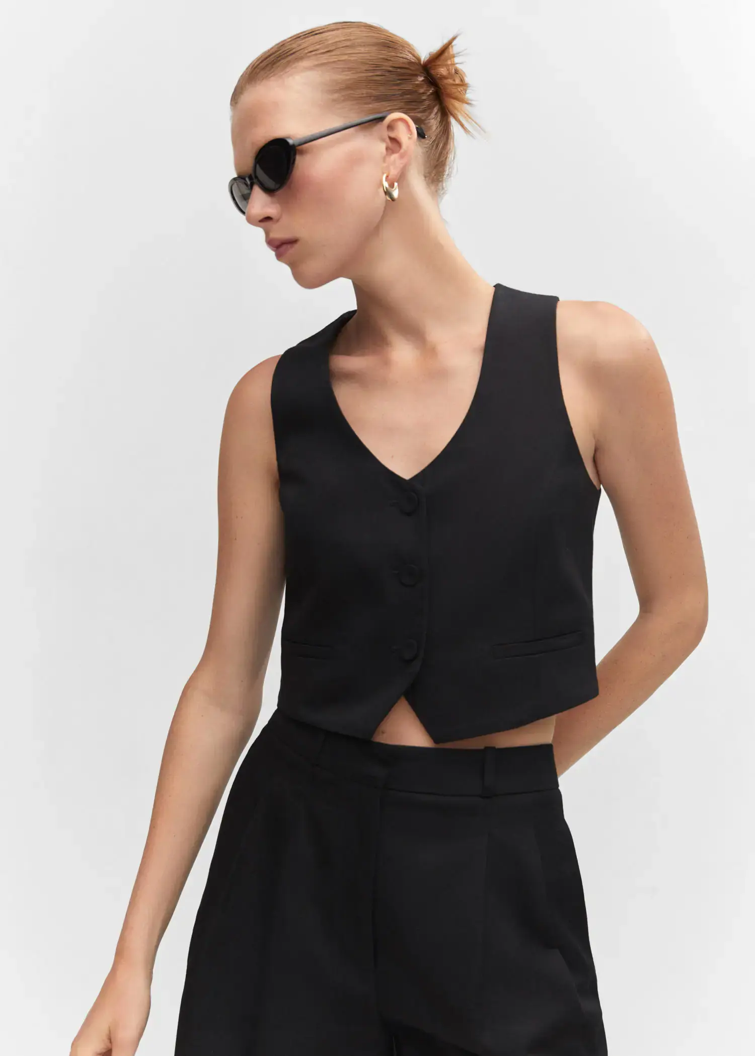 Mango Fitted vest with buttons. a woman wearing a black top and a black skirt. 