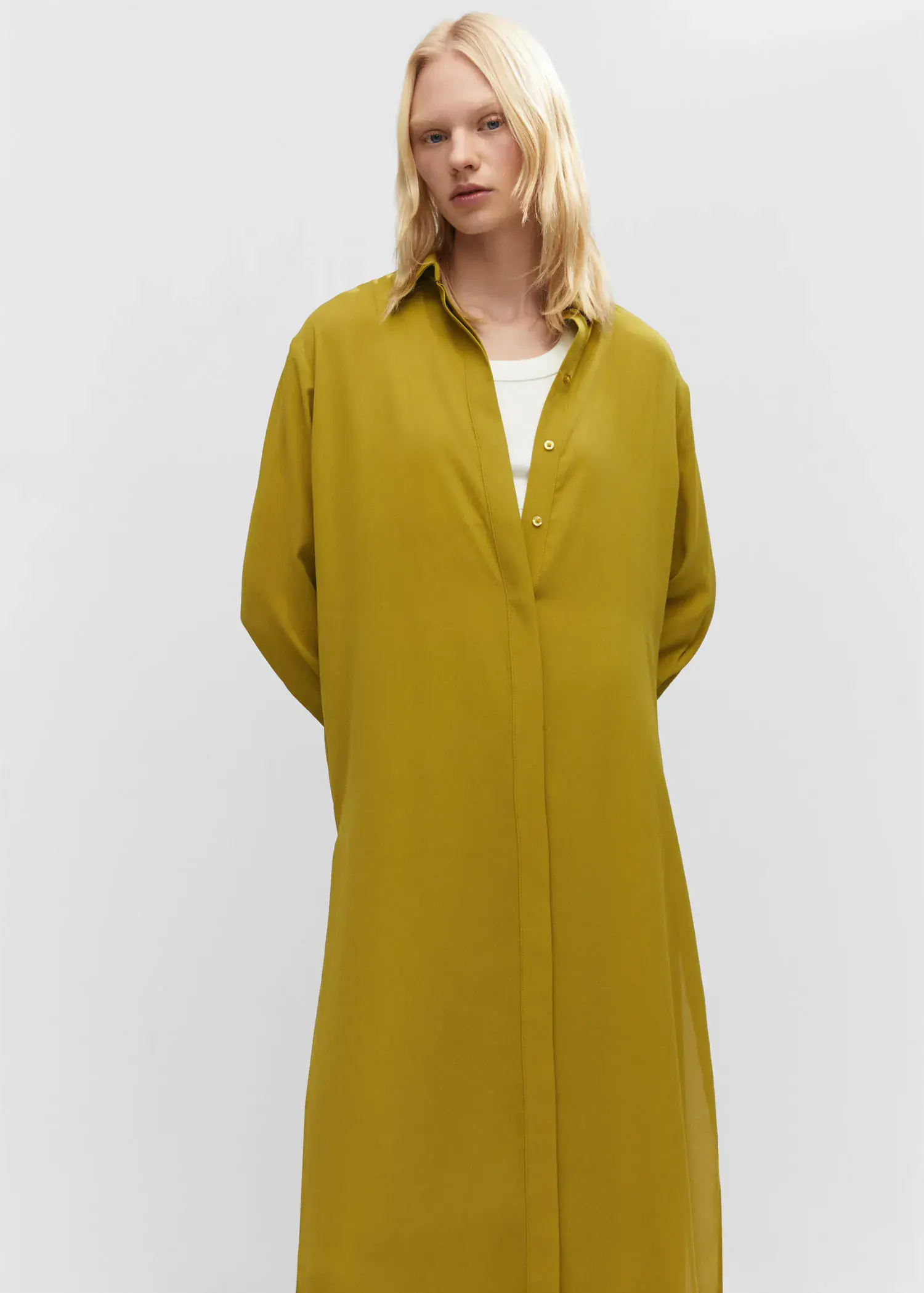 Mango Shirt dress with slits. a woman wearing a yellow dress standing in front of a white wall. 