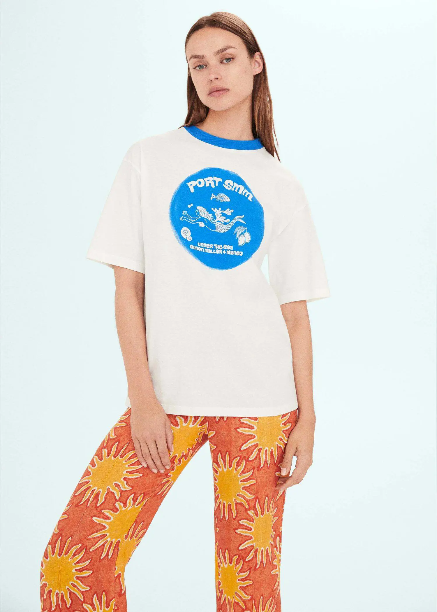 Mango Printed oversize t-shirt. a person wearing a white t-shirt and orange pants. 