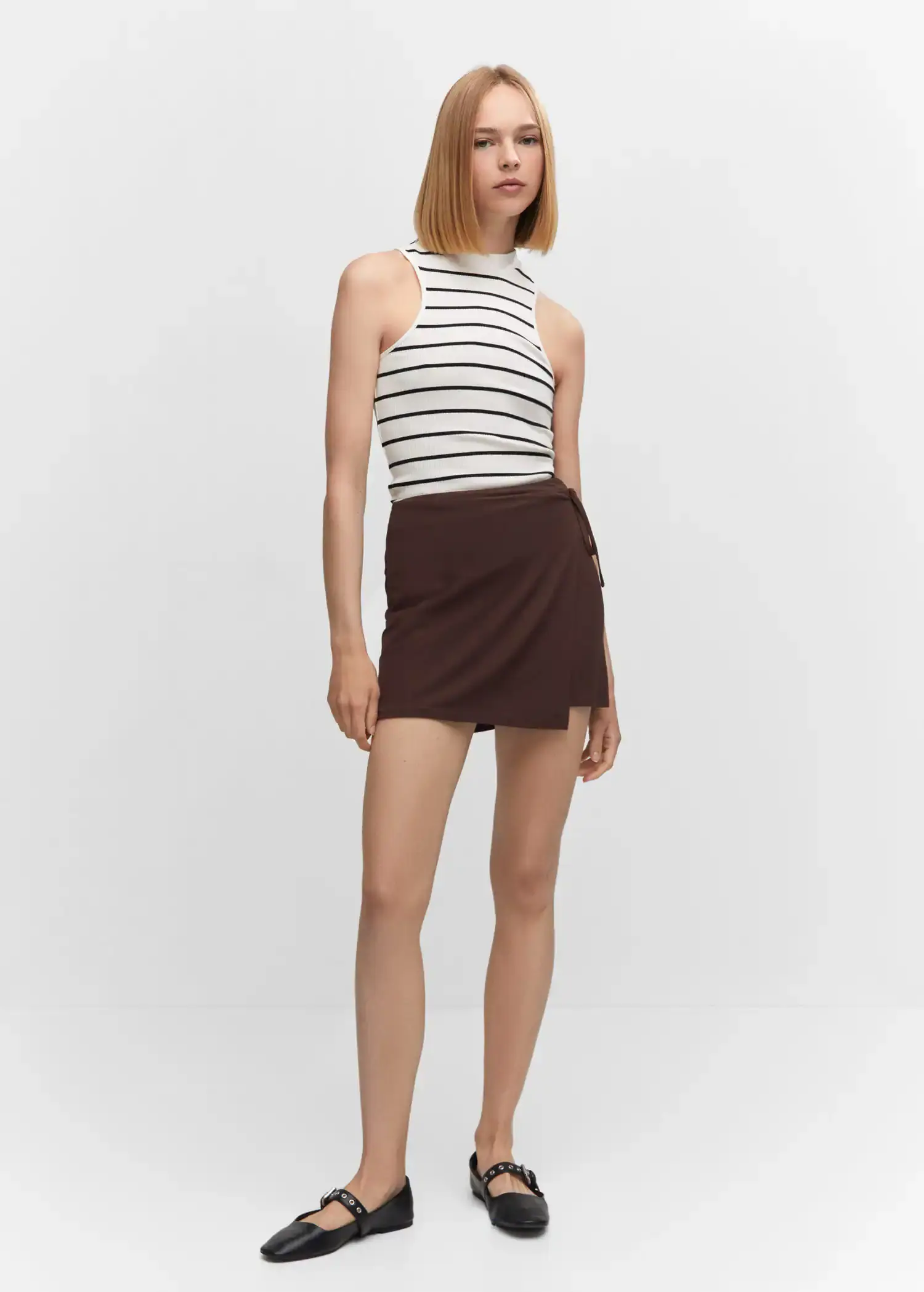 Mango Bow wrap skirt. a woman in a striped top and a brown skirt. 