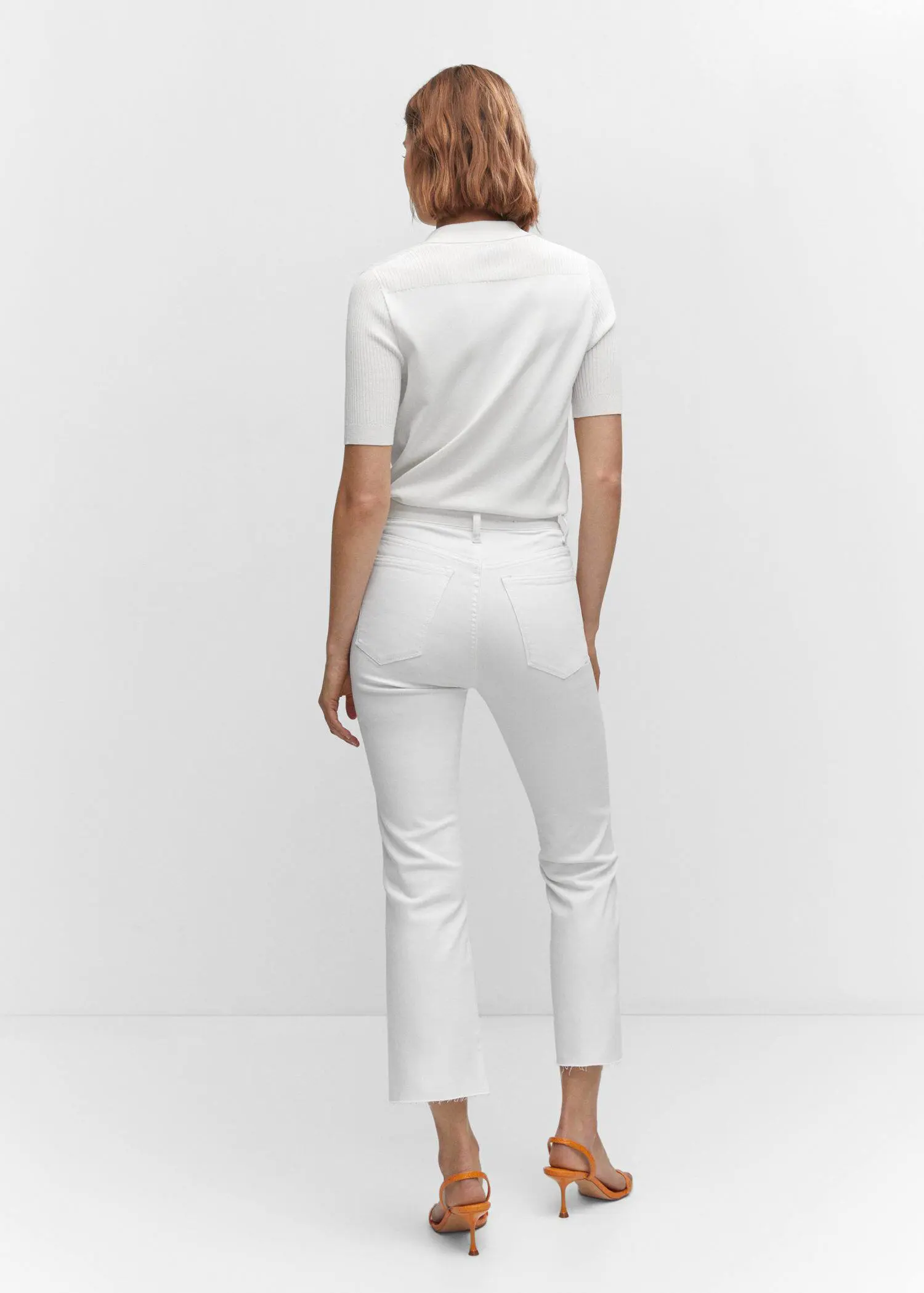 Mango Crop flared jeans. a person wearing white pants and a white shirt. 