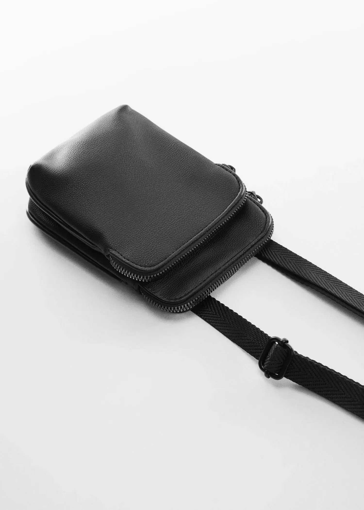 Mango Mini leather-effect shoulder bag. a black bag is sitting on a table. 