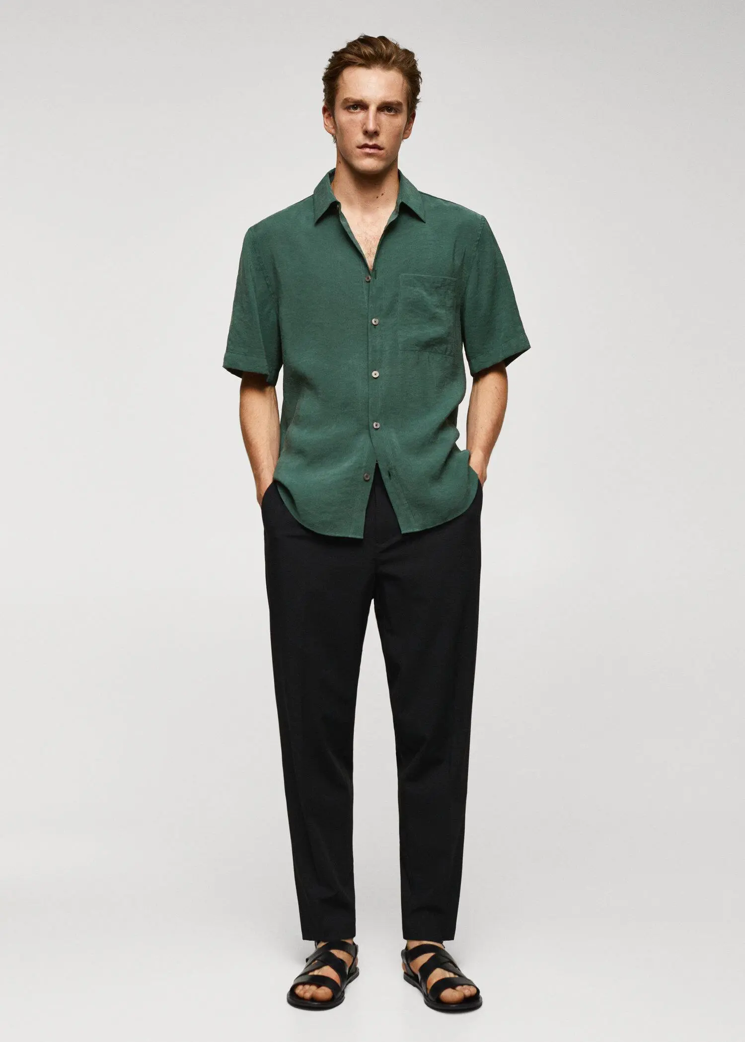 Mango Regular-fit short-sleeved shirt. a man wearing a green shirt and black pants. 