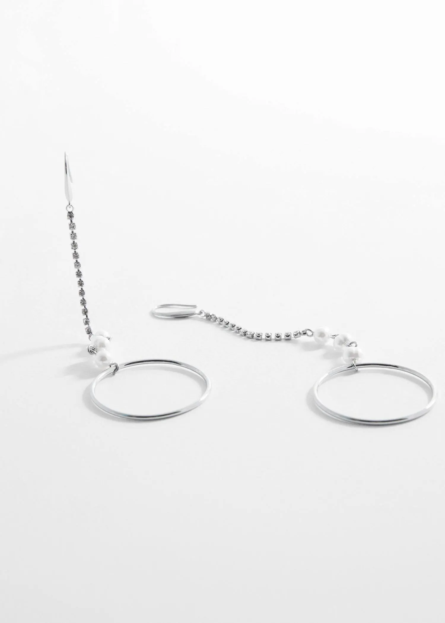 Mango Rhinestone thread hoop earrings. a pair of metal rings and a chain on a white surface. 