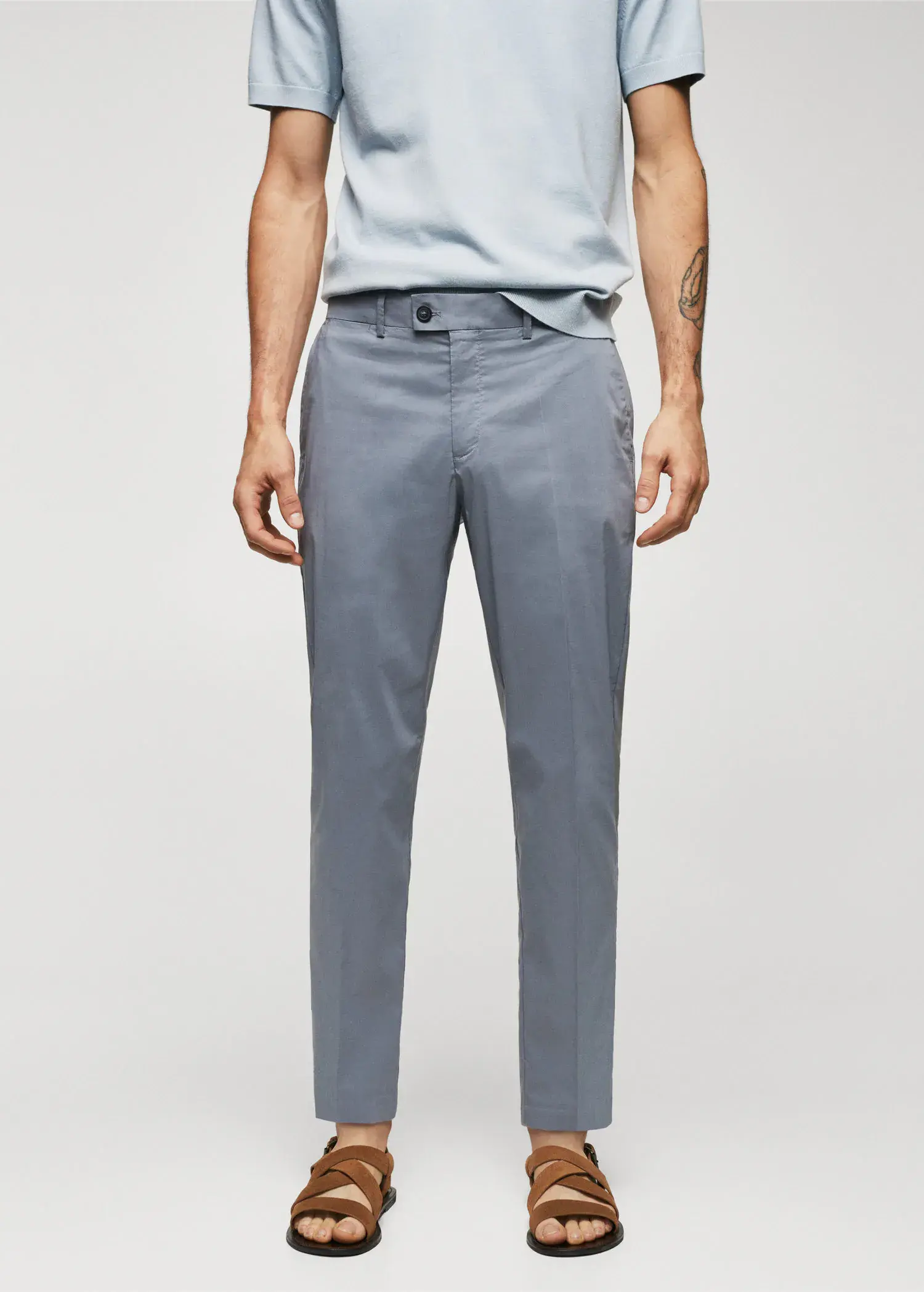 Mango Lightweight cotton trousers. a man standing in front of a white wall. 