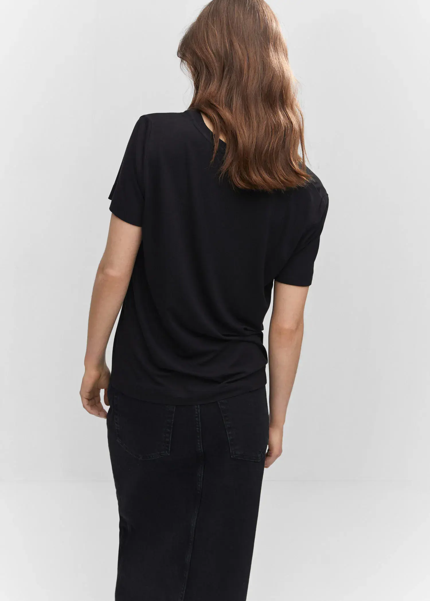 Mango V-neck T-shirt. a woman wearing a black shirt and a black skirt. 