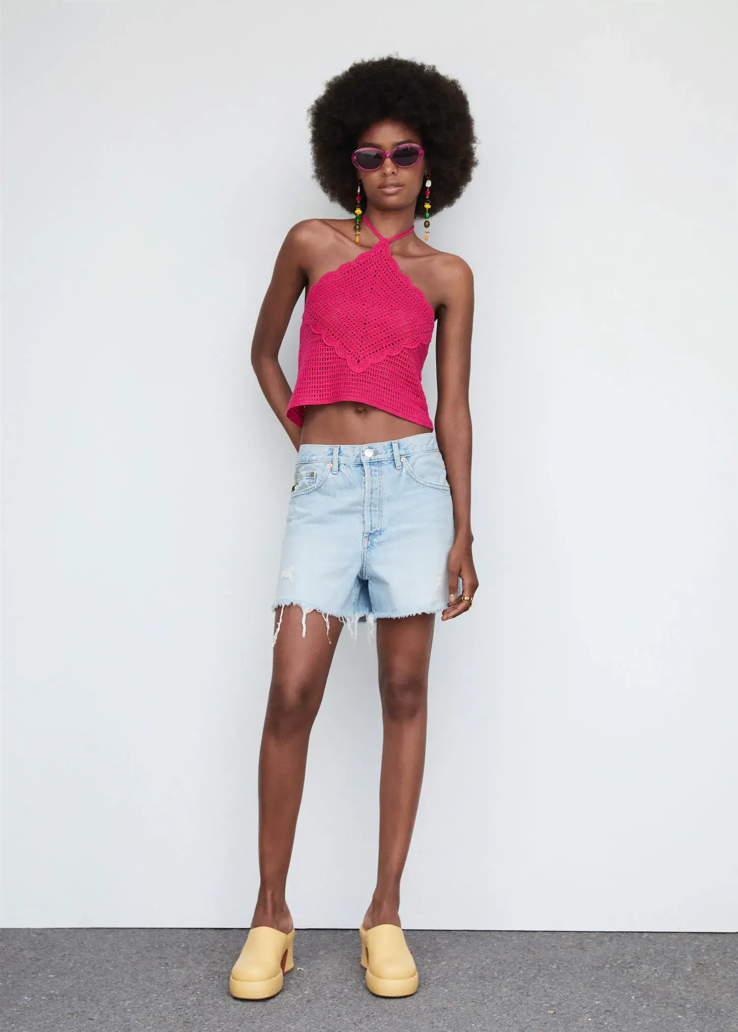 Mango Bow collar top. a woman in a pink top and denim shorts. 