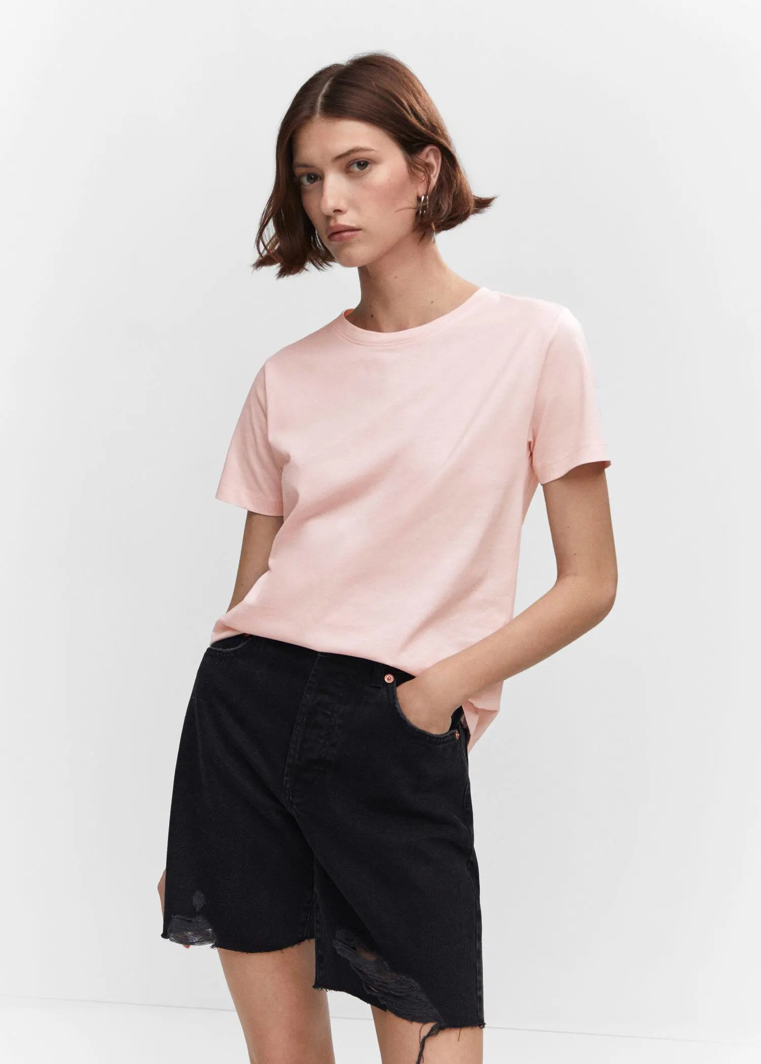 Mango 100% cotton T-shirt. a woman wearing black shorts and a light pink t-shirt. 