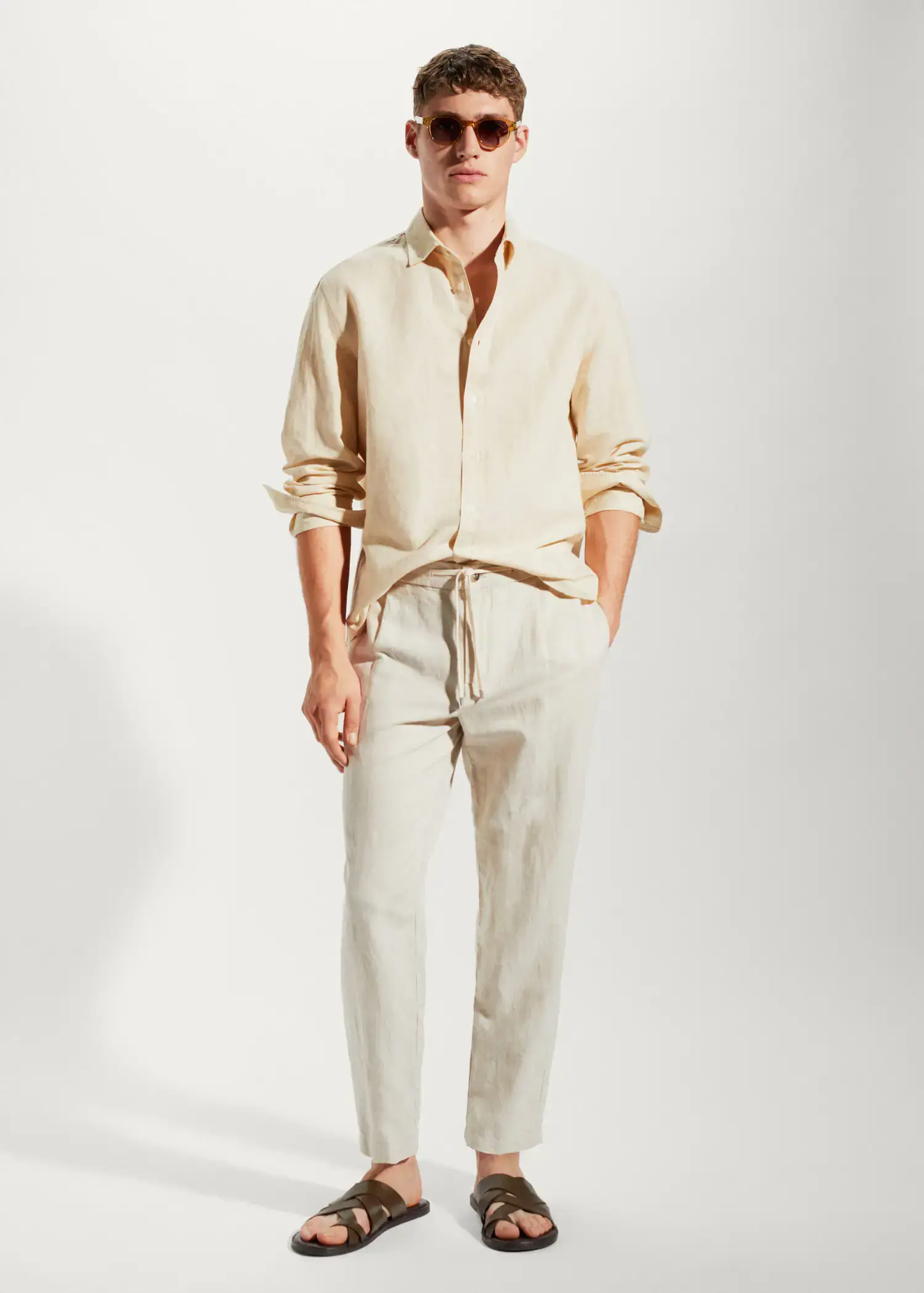 Mango Regular-fit linen cotton shirt. a man in a tan shirt and white pants. 
