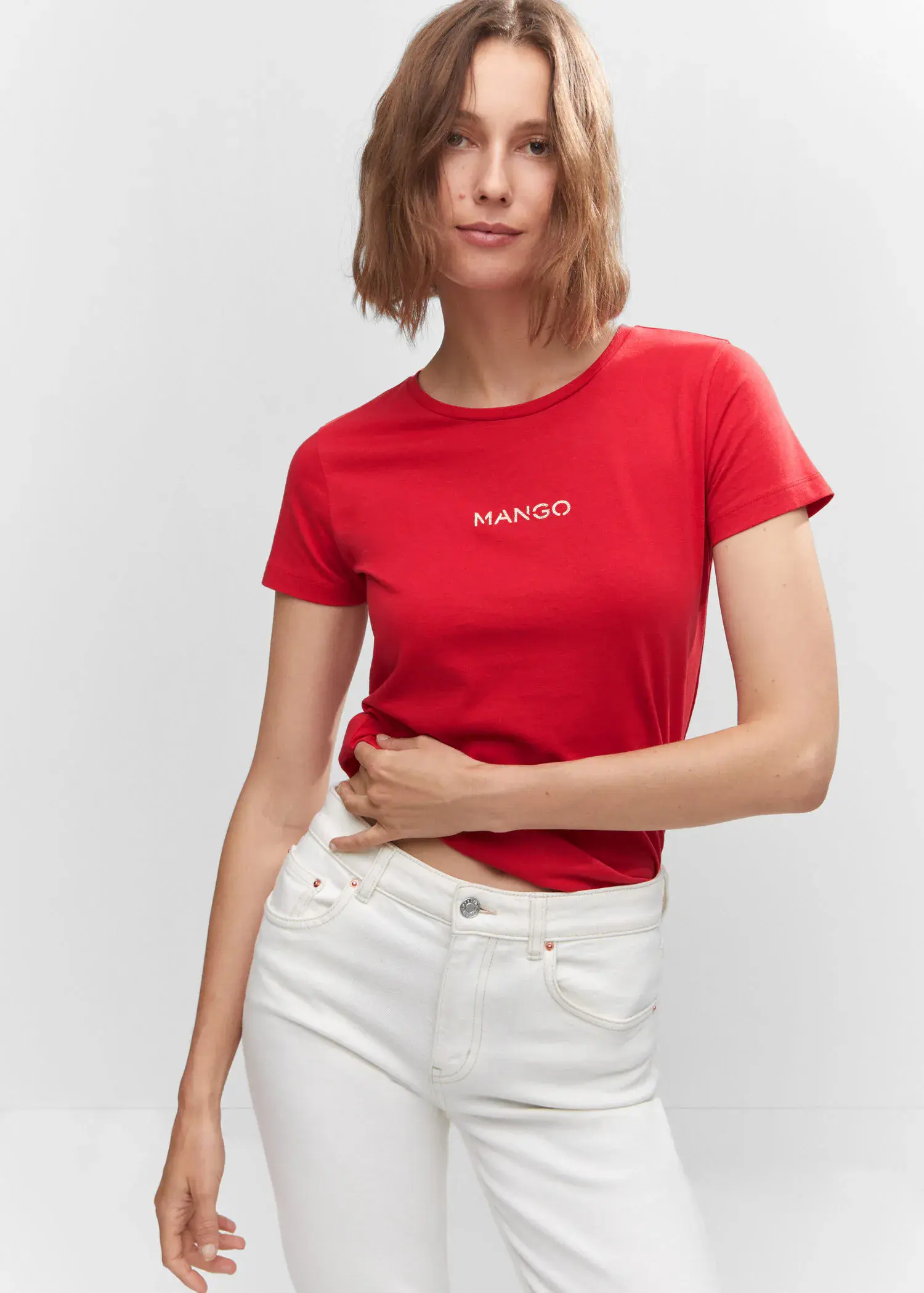 Mango Metallic logo T-shirt. a woman in a red shirt and white jeans. 