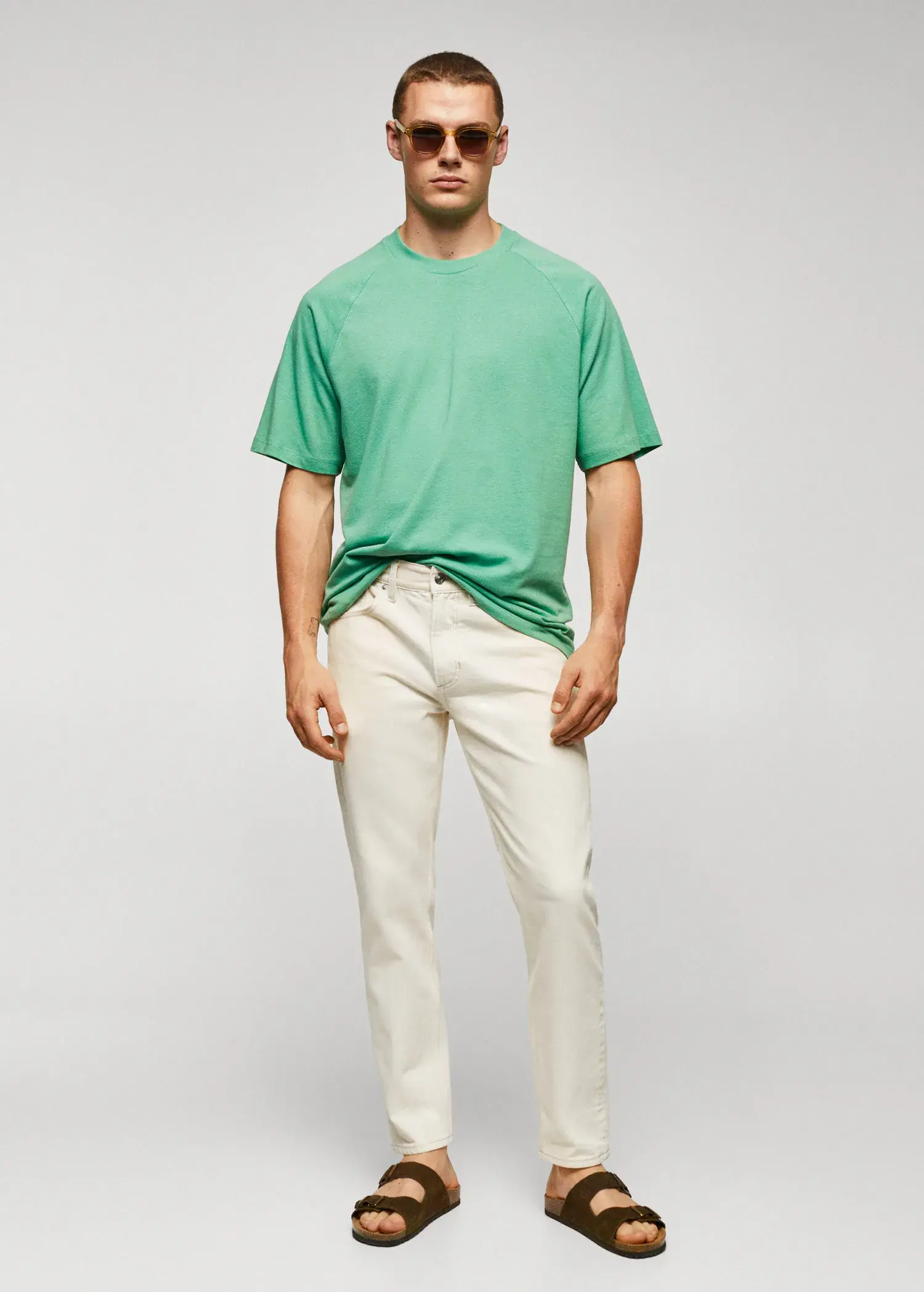 Mango Textured cotton-linen t-shirt. a man wearing a green shirt and white pants. 