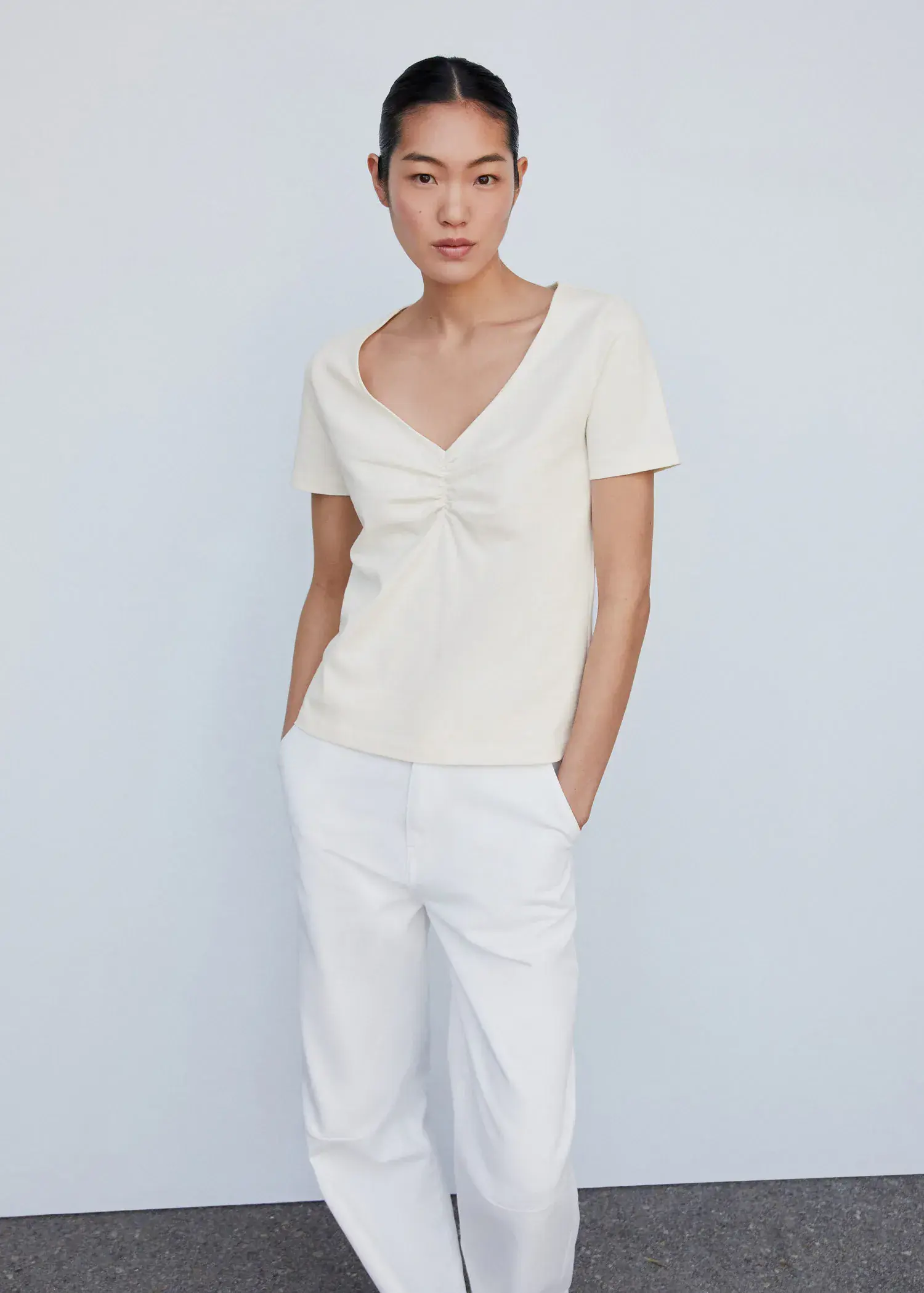 Mango Cotton t-shirt with pucker detail. a woman wearing white pants and a white top. 