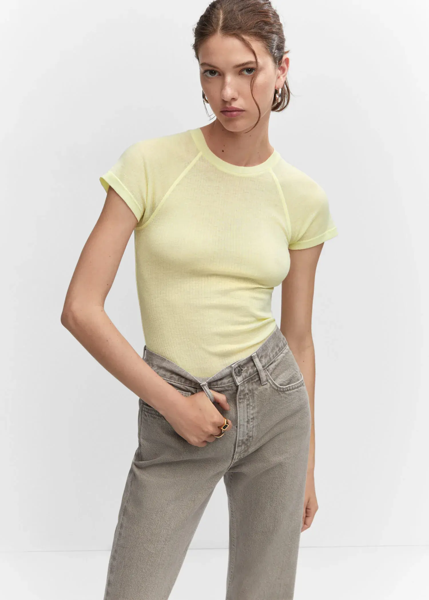 Mango Seam detail T-shirt. a woman in a yellow shirt and gray pants. 