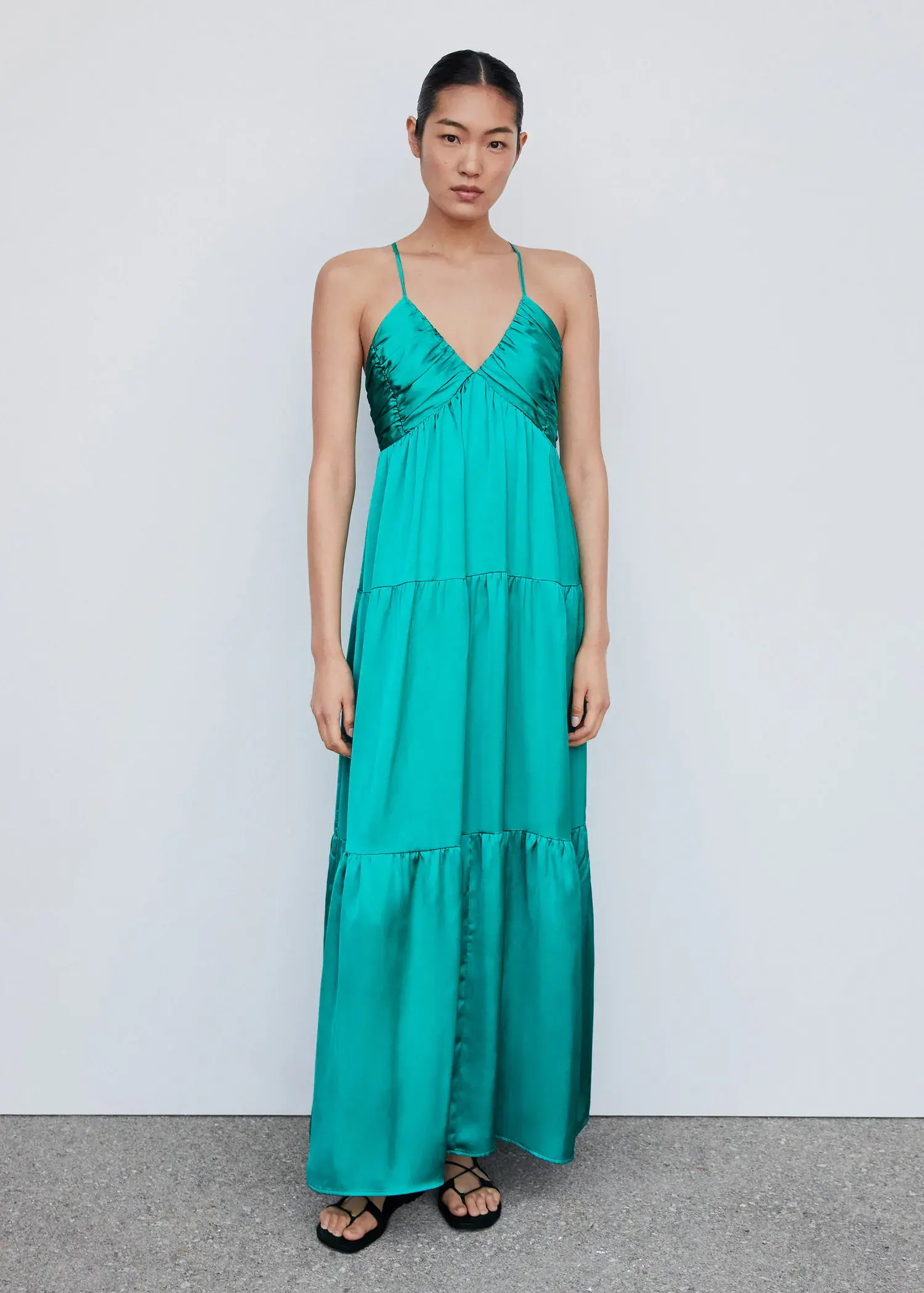 Mango Ruched satin dress. a woman wearing a long green dress standing in front of a wall. 
