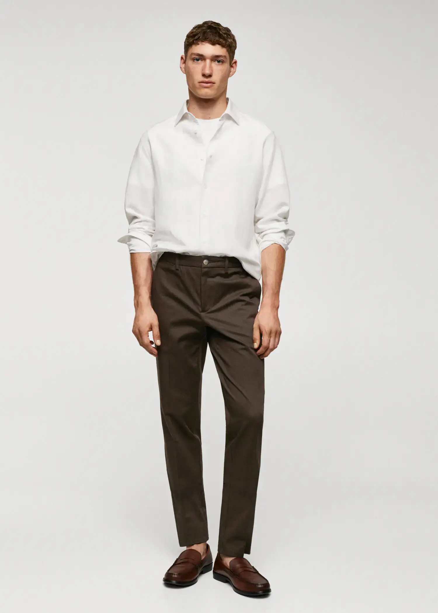 Mango Slim fit chino trousers. a man wearing a white shirt and brown pants. 