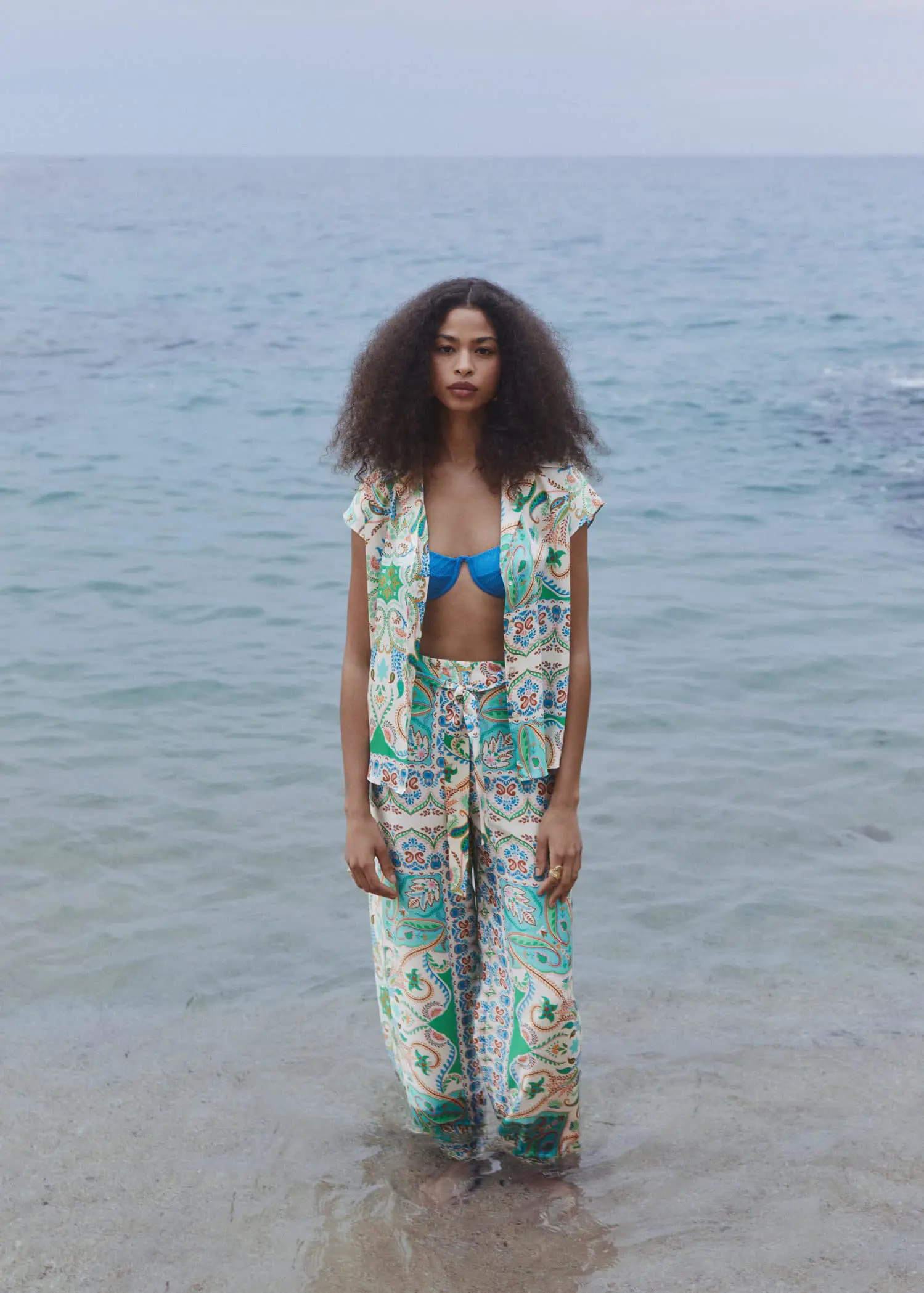Mango Satin print shirt. a woman standing on the beach wearing a bikini top. 