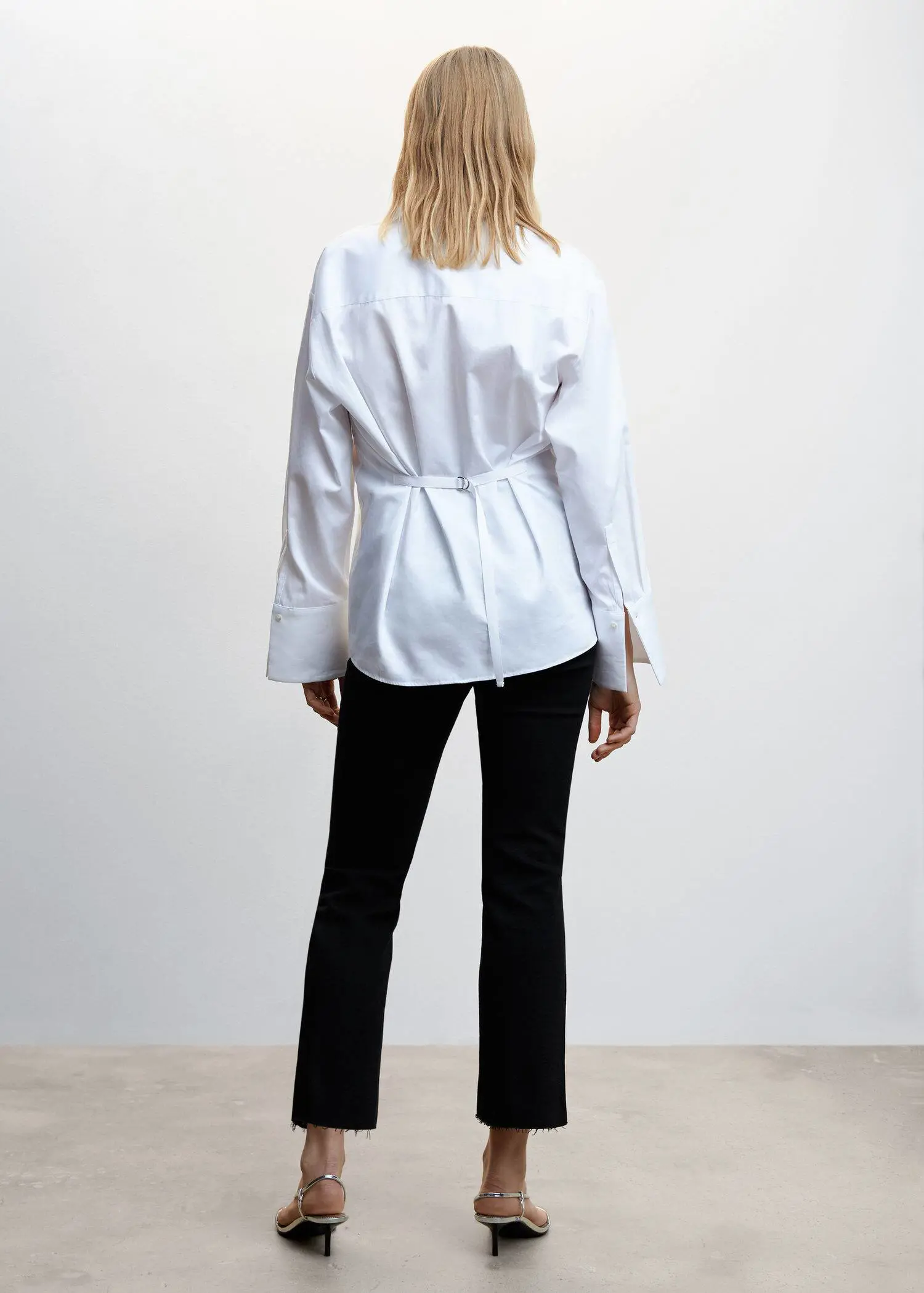 Mango Maternity flared cropped jeans. a woman wearing a white shirt and black pants. 