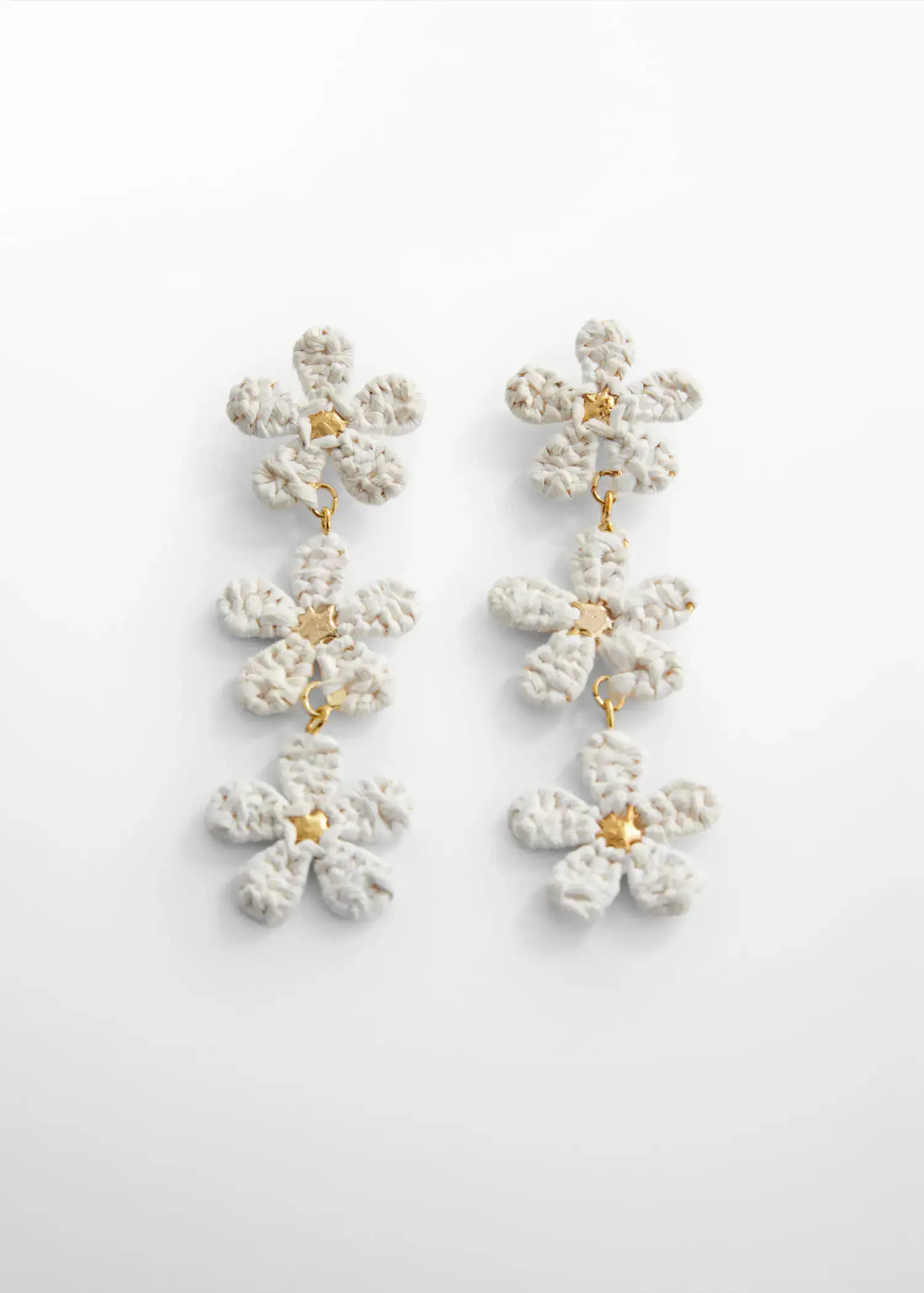 Mango Flowers raffia earrings. a pair of white flower earrings on a white surface. 