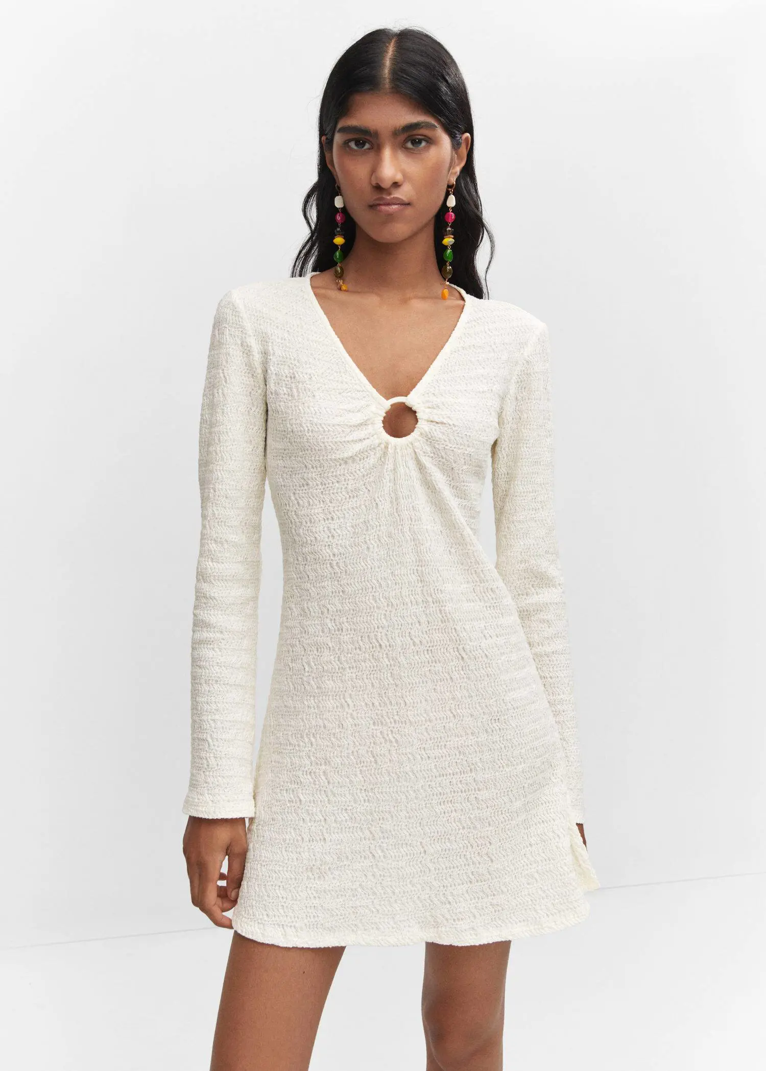 Mango Textured dress with hoop detail. a woman wearing a white dress with long sleeves. 