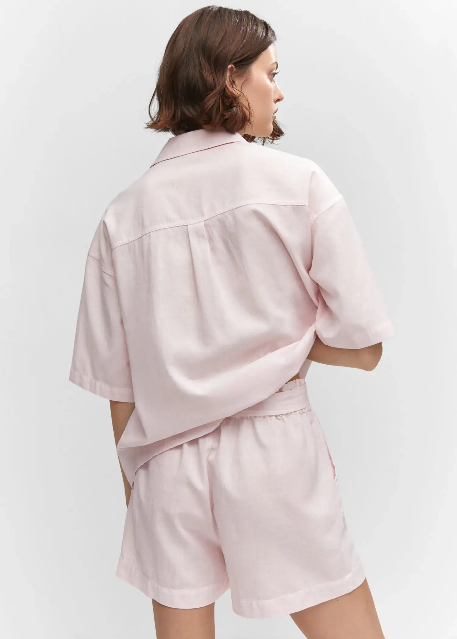 Mango Cotton linen shorts. a person wearing a light pink shirt. 