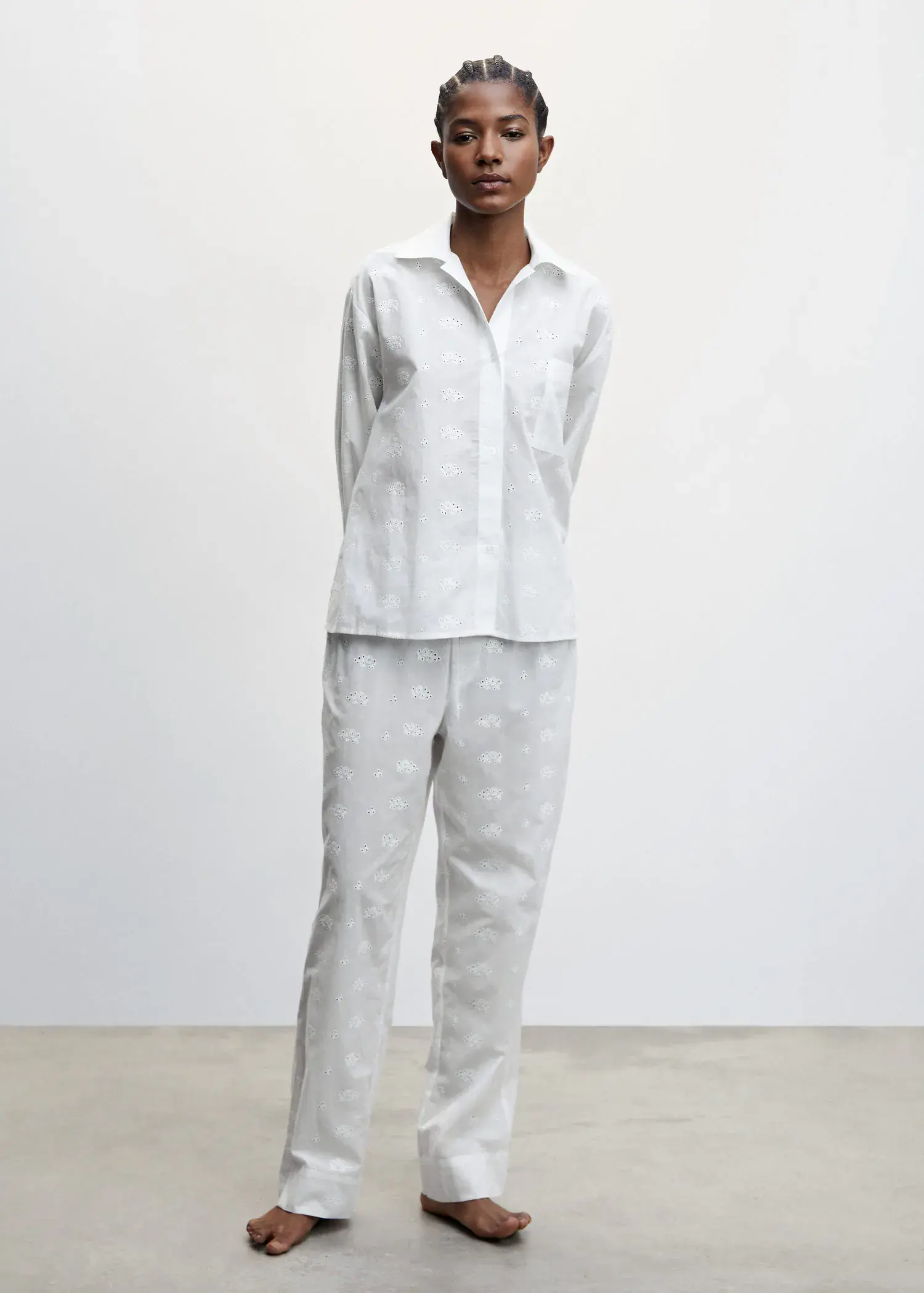 Mango Pyjama trousers with openwork details. a person standing in a room wearing a white outfit. 