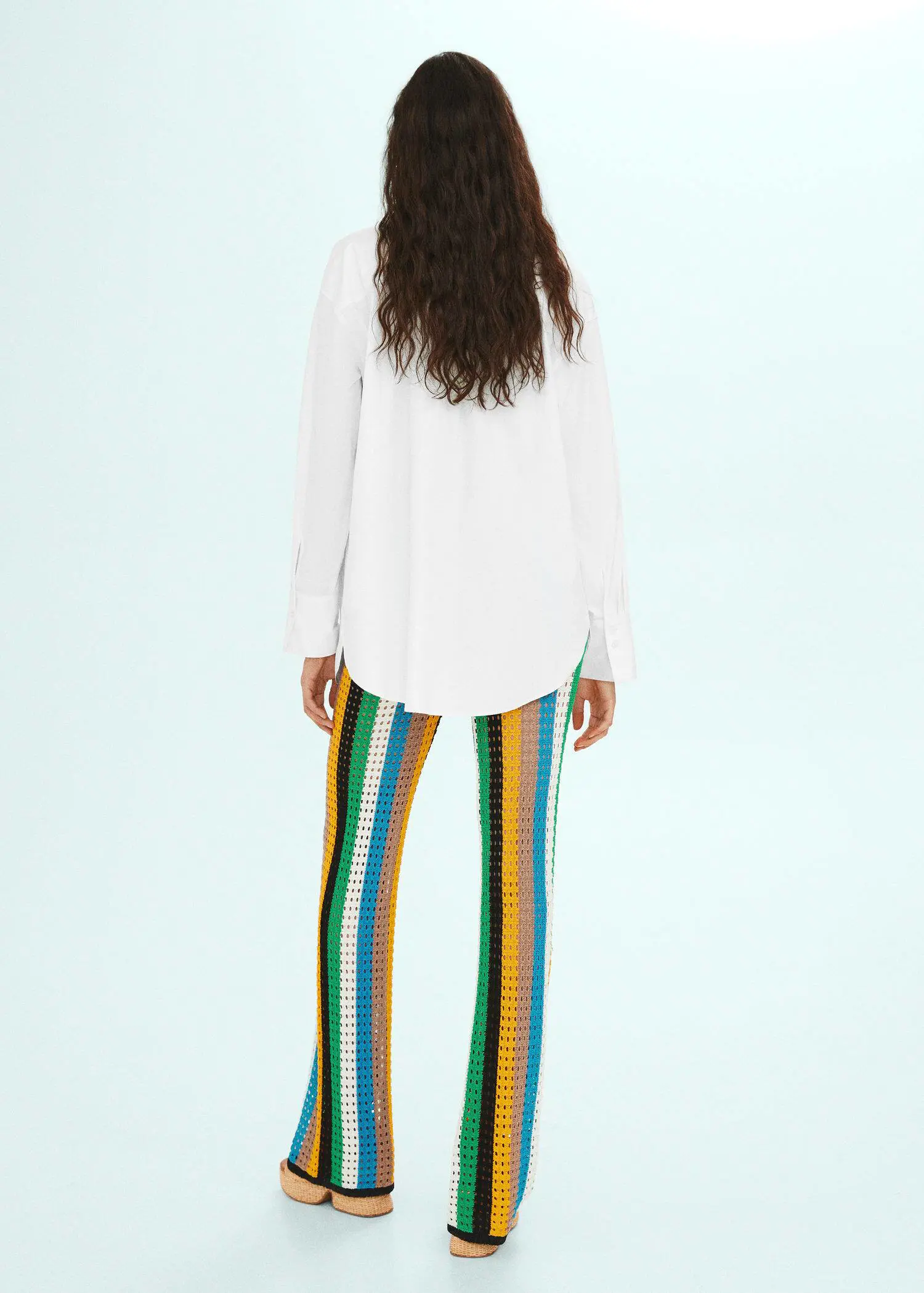 Mango Oversized shirt with embroidered detail. a woman in a white shirt and multicolored pants. 