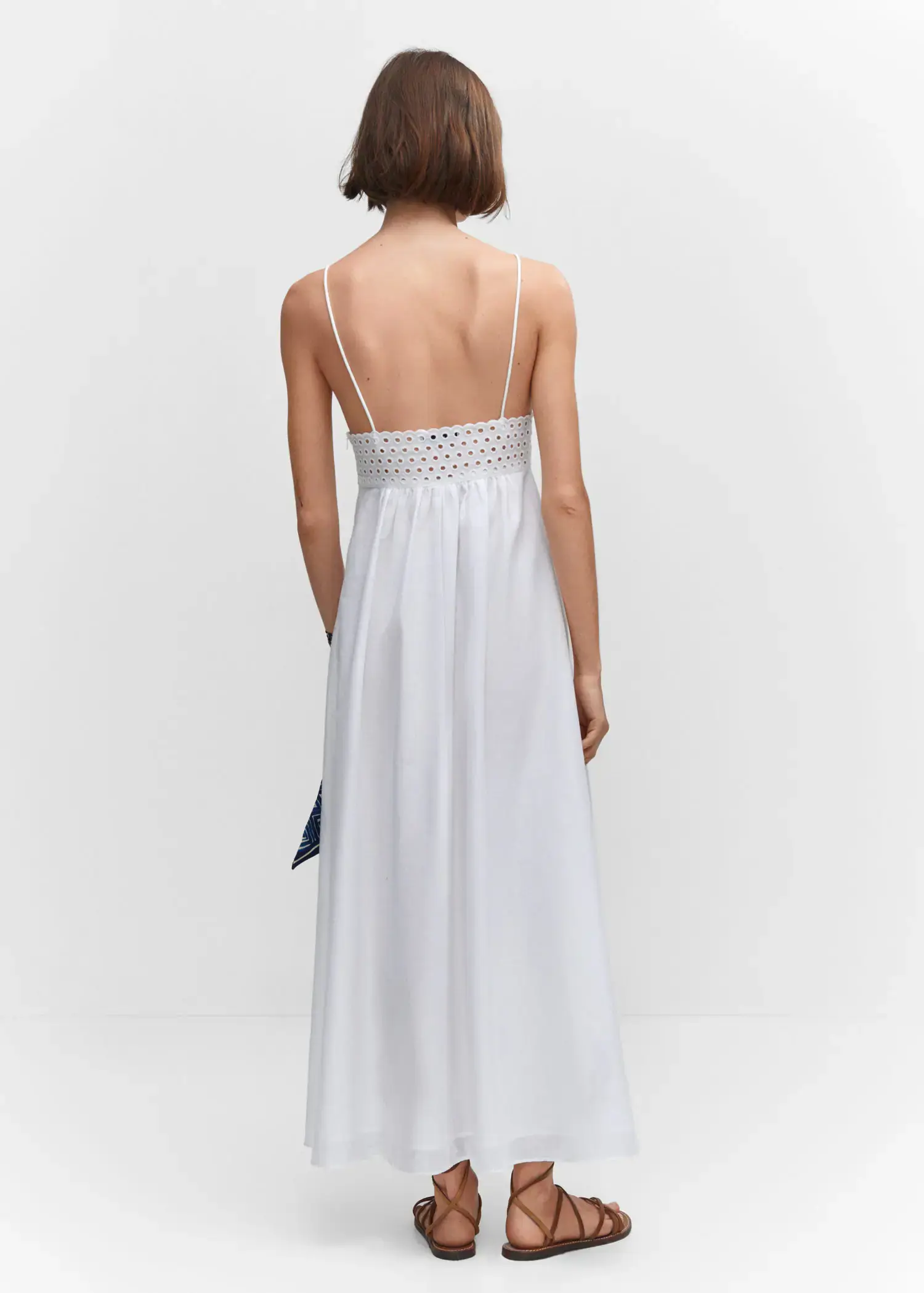 Mango Embroidered v-neckline dress. a woman in a white dress standing in front of a white wall. 