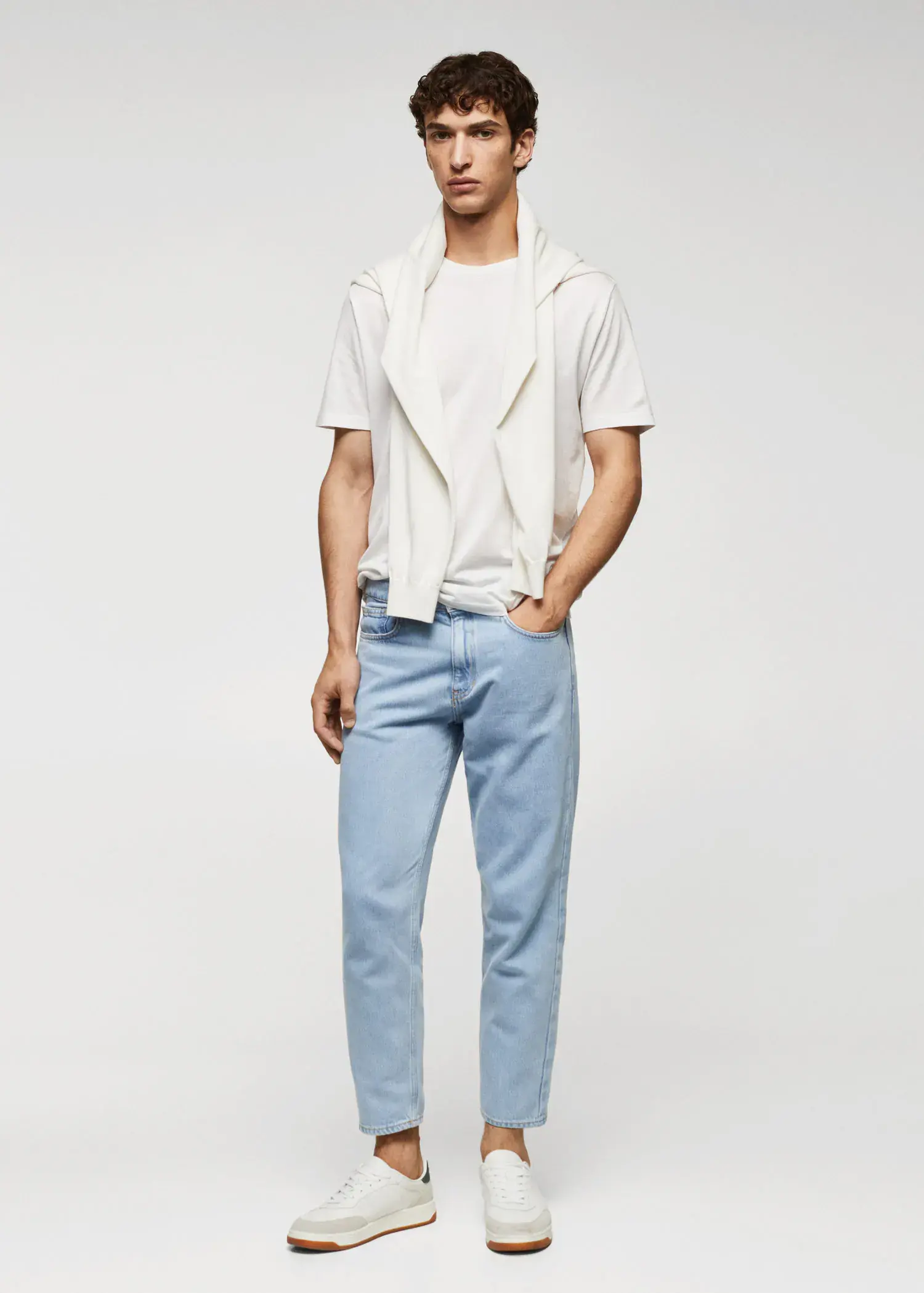 Mango Lightweight light-wash tapered-fit jeans. a young man wearing a white shirt and blue pants. 