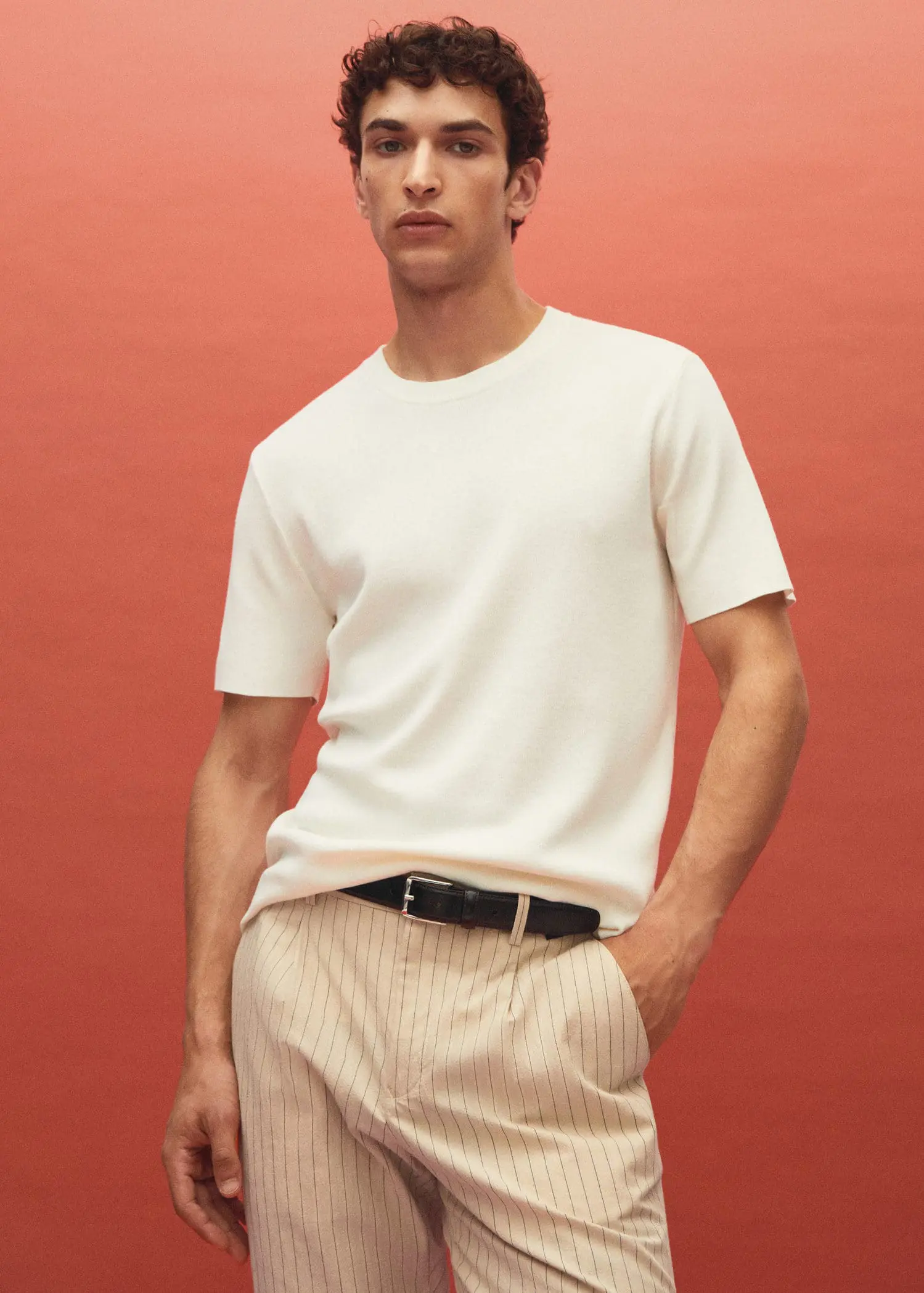 Mango Cotton fine-knit t-shirt. a man in a white shirt and brown pants. 
