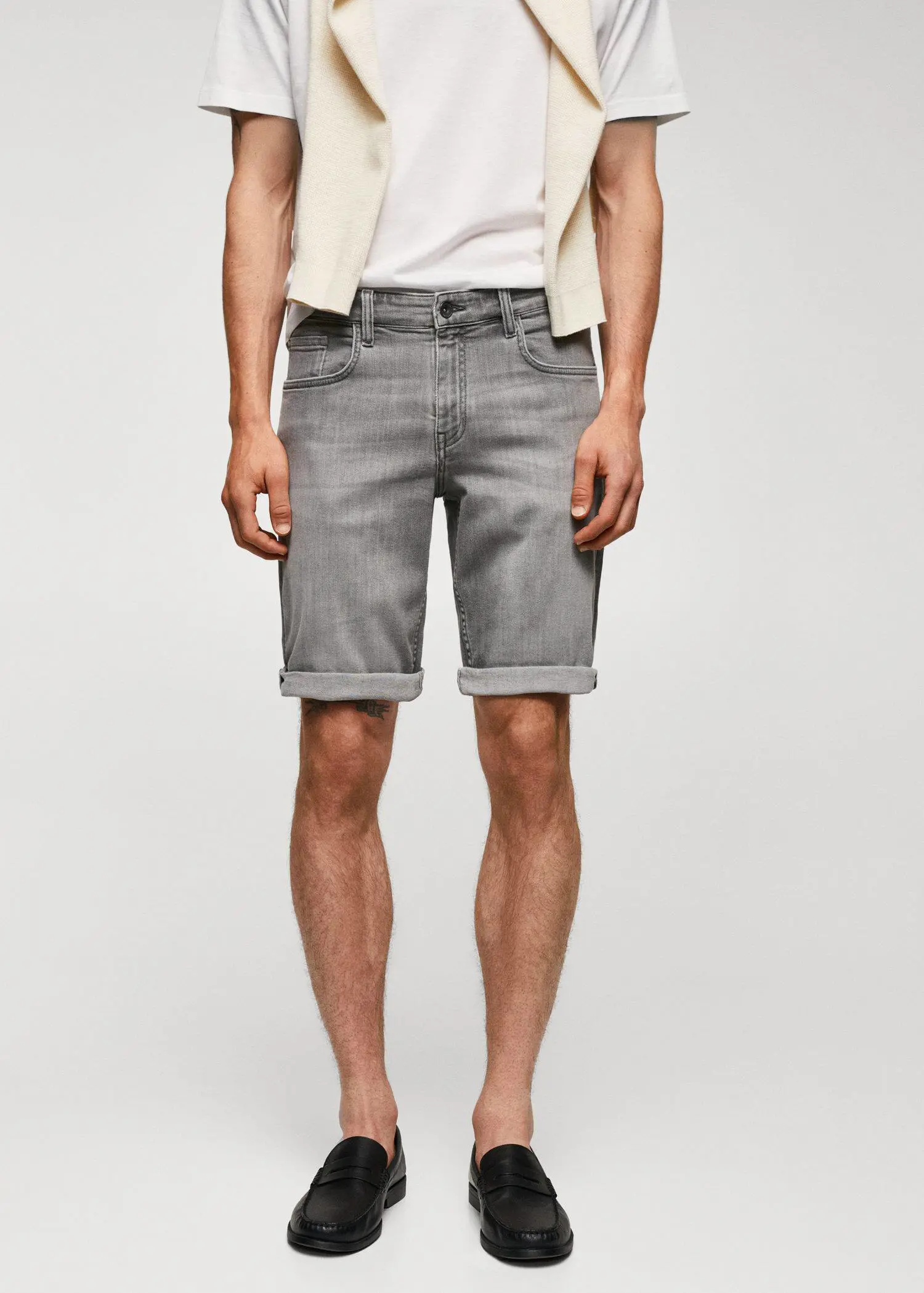 Mango Slim-fit denim bermuda shorts. a man wearing grey shorts and a white shirt. 