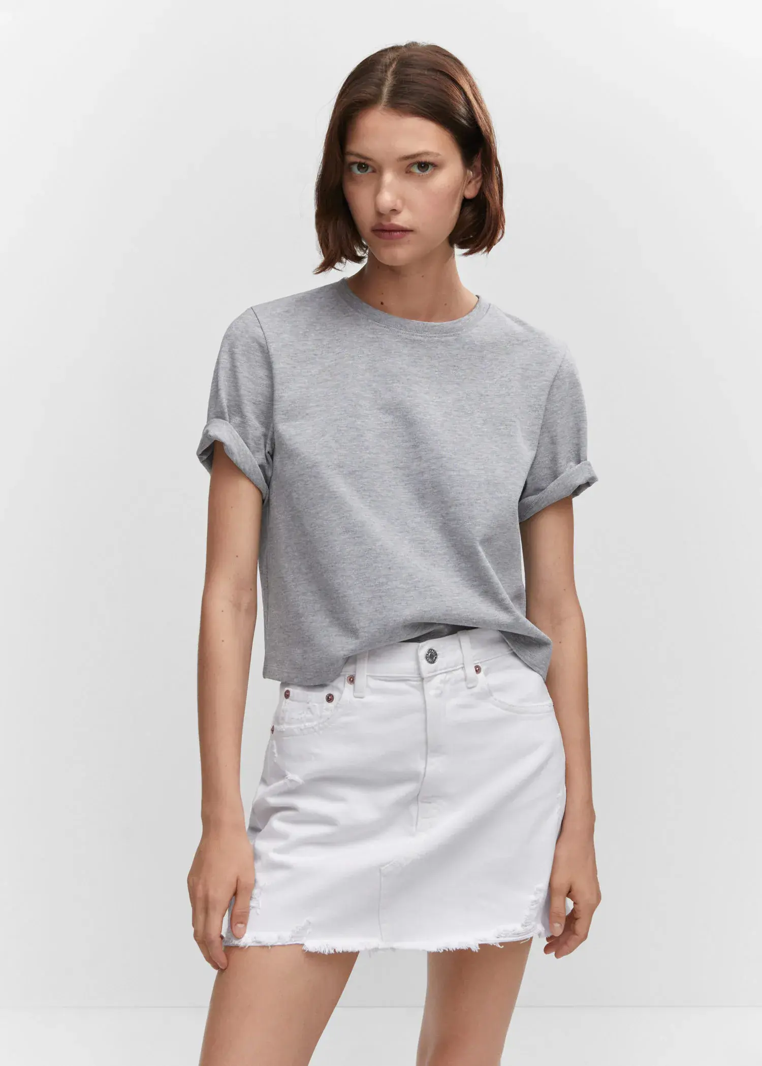 Mango Denim mini-skirt. a woman wearing a gray t-shirt and a white skirt. 