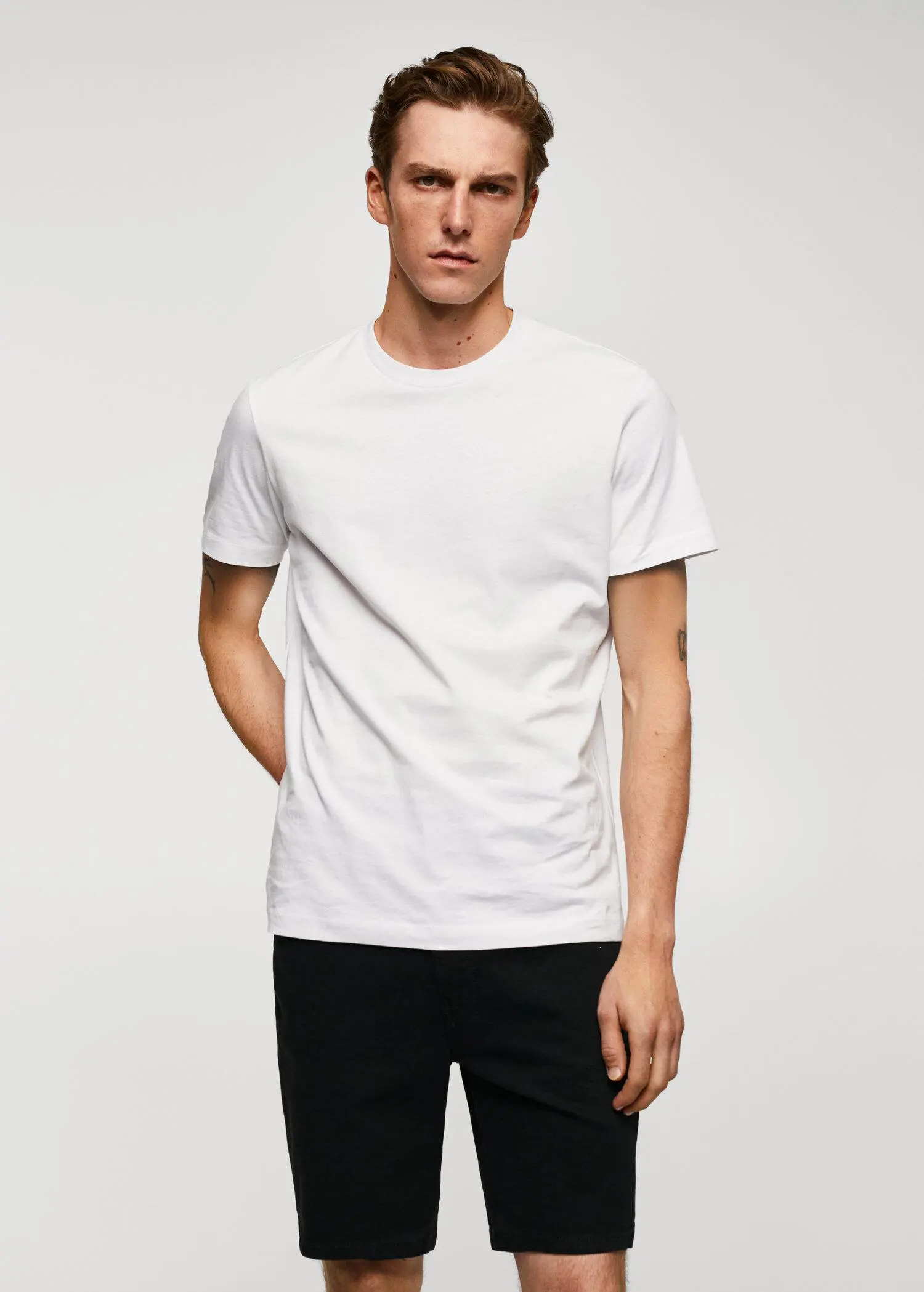 Mango Basic cotton stretch T-shirt. a man in a white t-shirt is posing for a picture. 