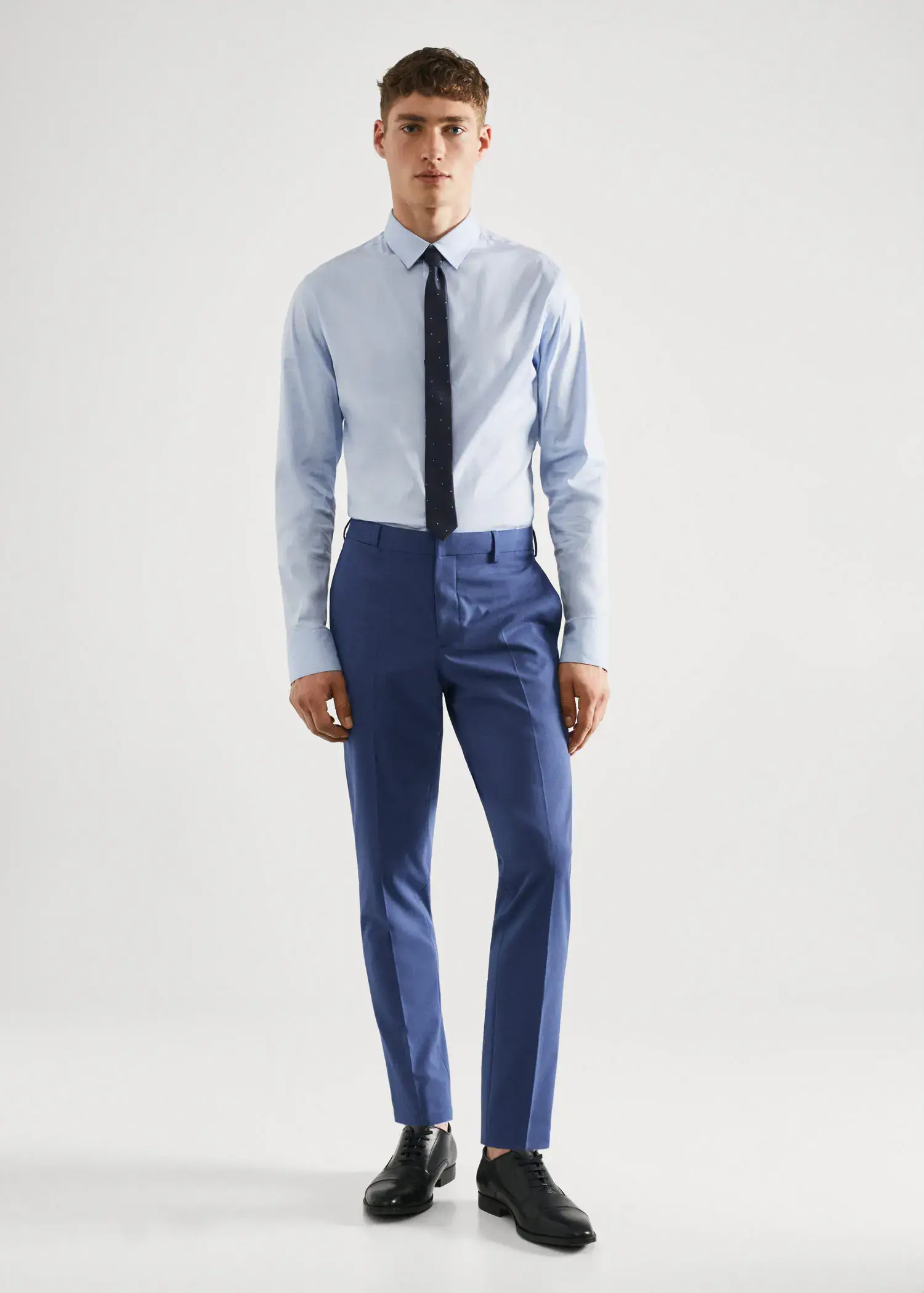 Mango Stretch fabric super slim-fit suit trousers. a man in a blue suit and a tie. 