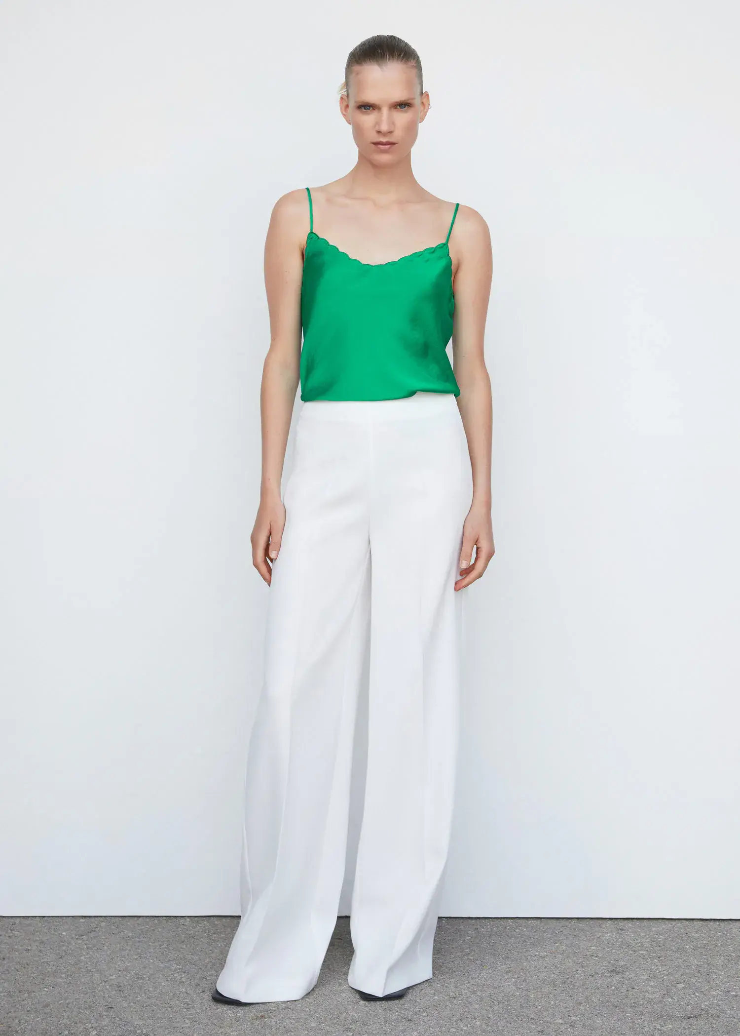Mango Satin lace top. a woman wearing a green top and white pants. 
