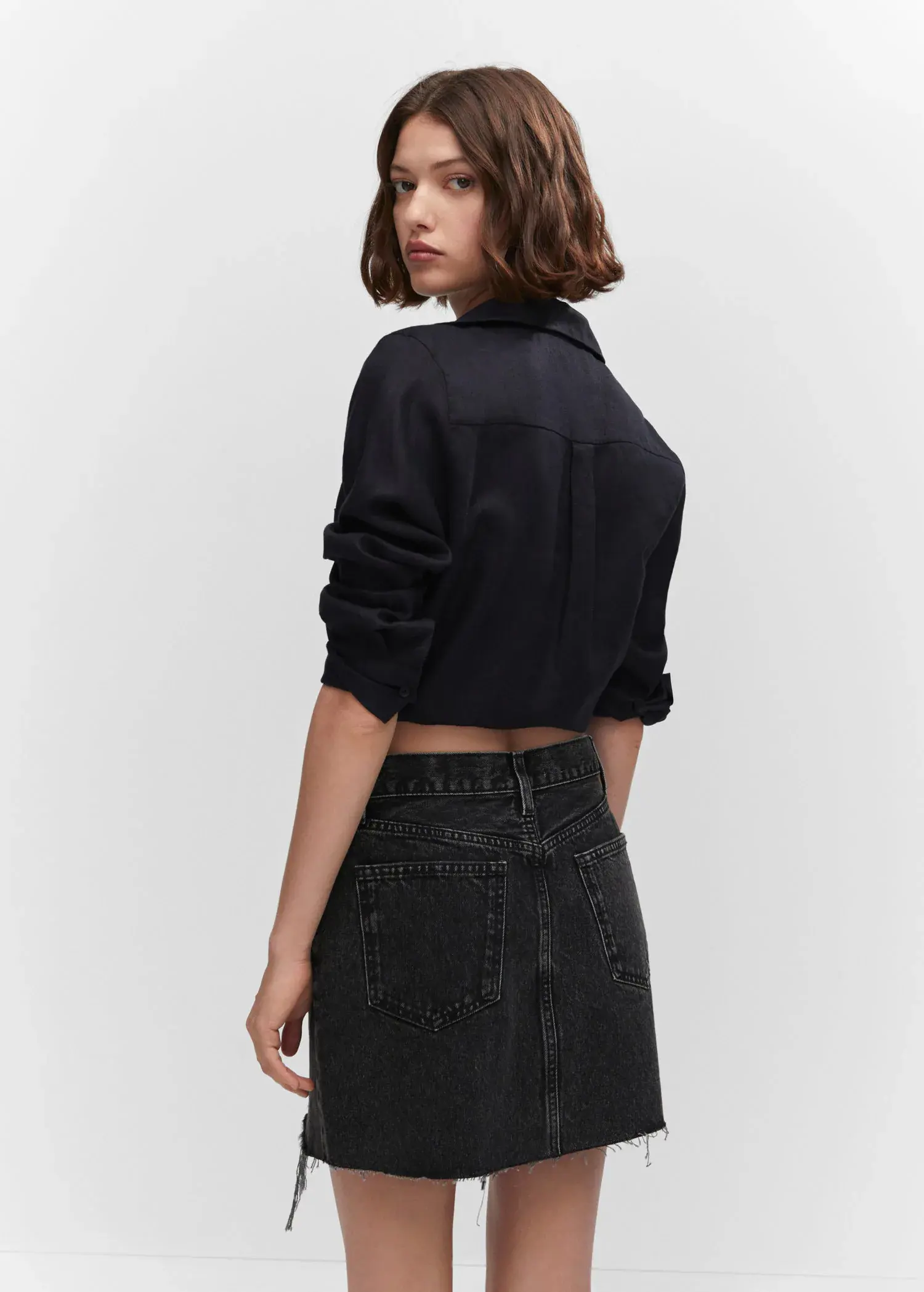 Mango Denim mini-skirt. a woman wearing a black shirt and a black skirt. 