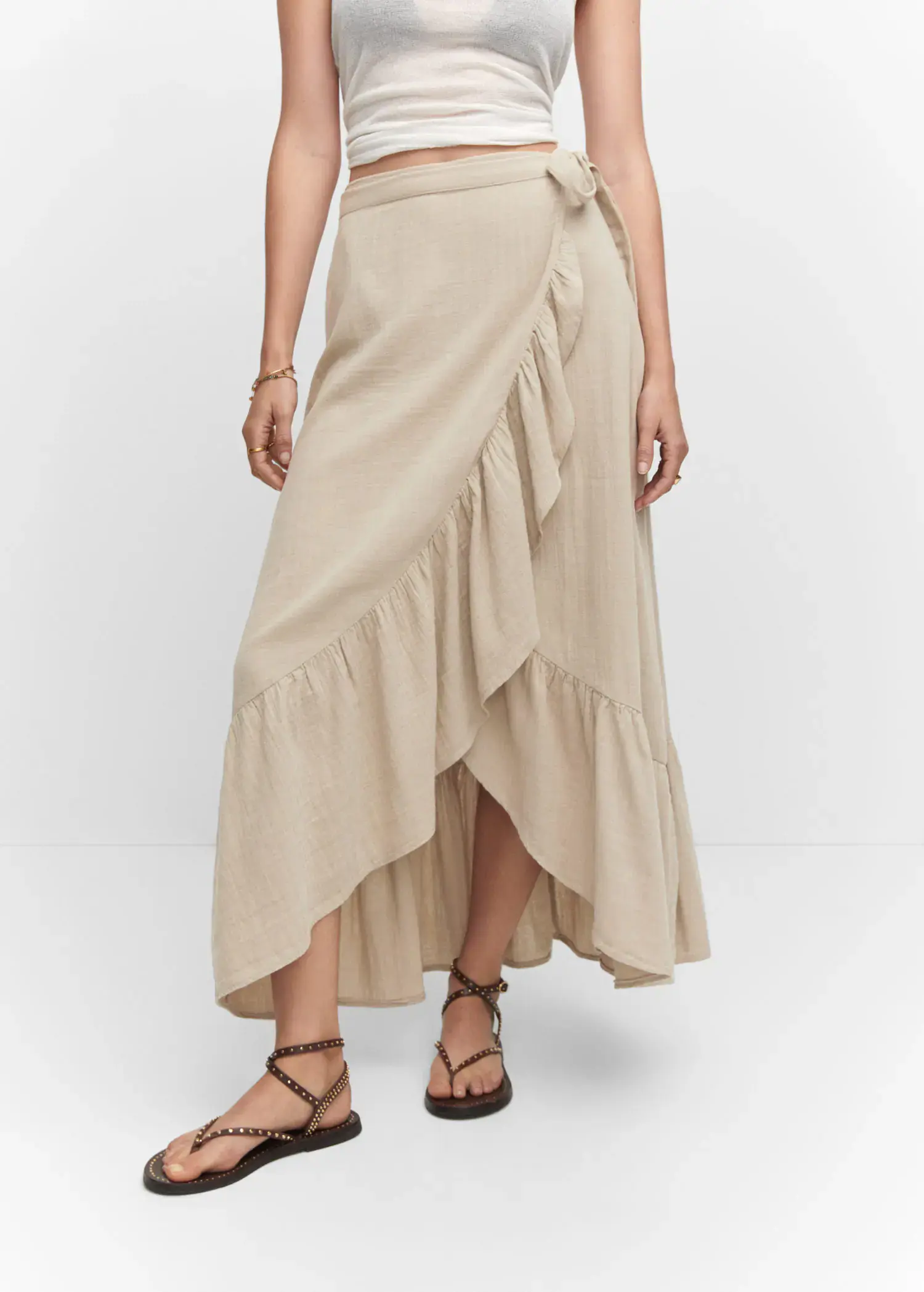 Mango Textured criss-cross skirt. a woman wearing a beige skirt and sandals. 