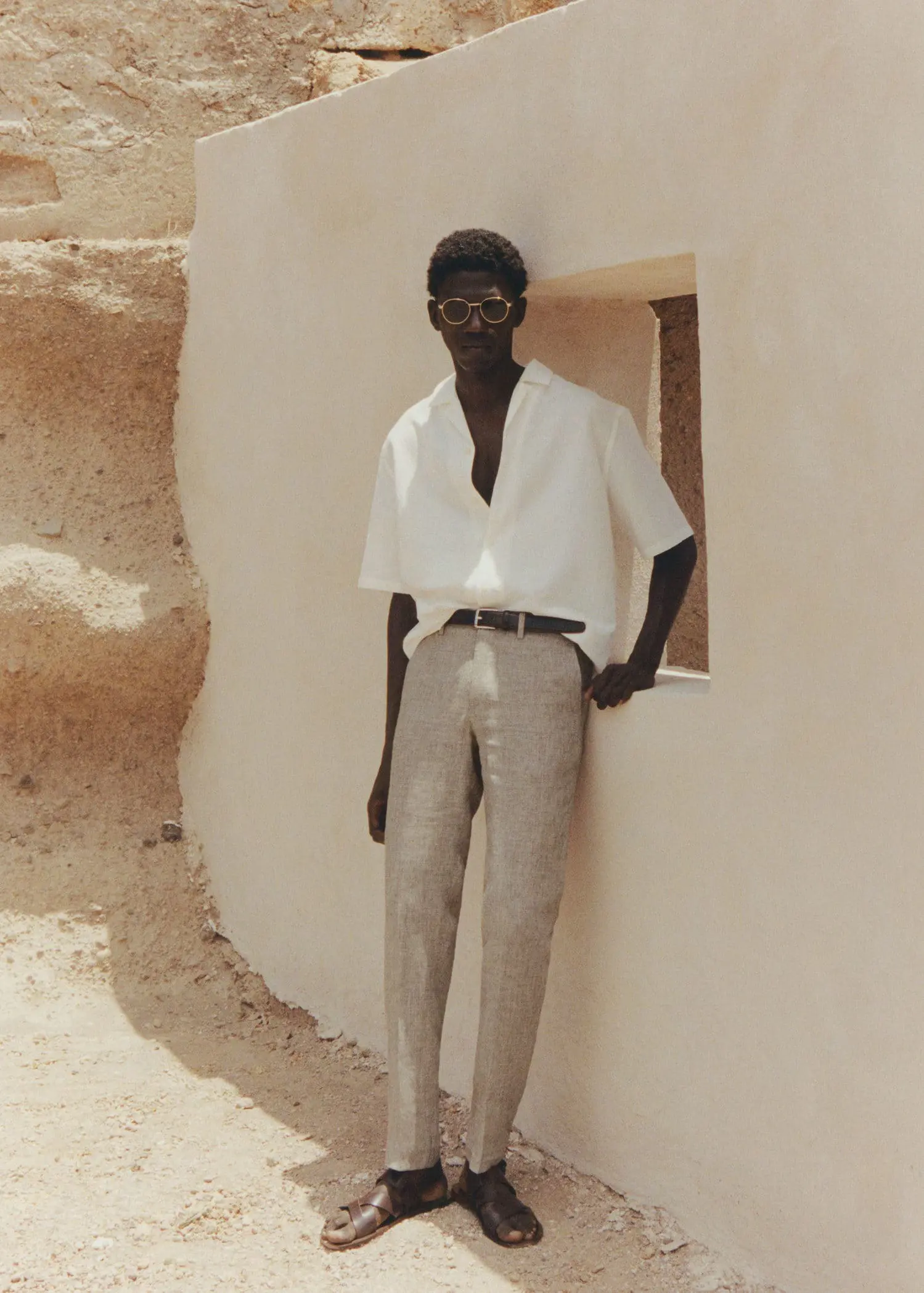 Mango 100% linen suit trousers. a man leaning up against a wall wearing sunglasses. 