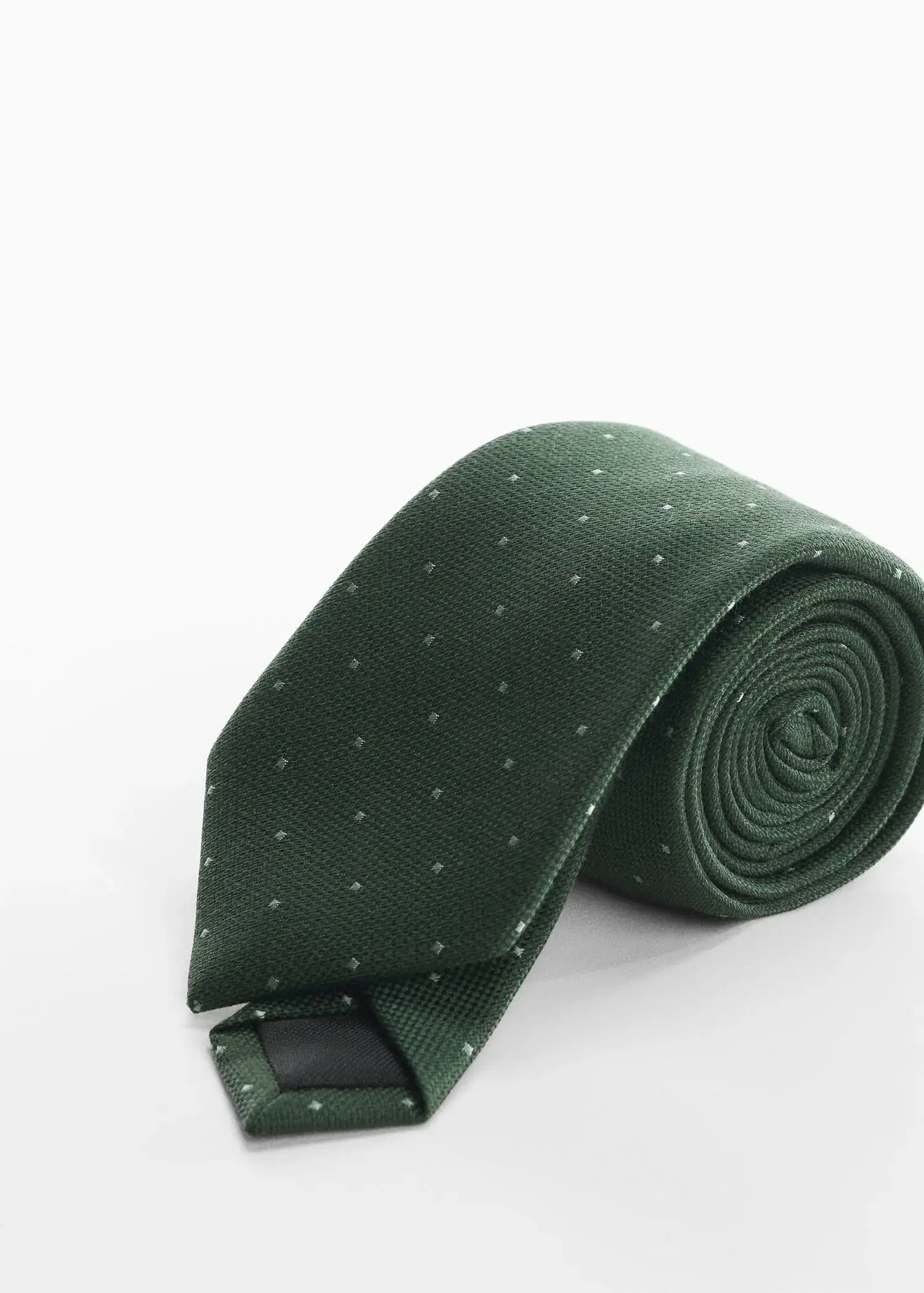 Mango Tie with micro polka-dot structure. a green neck tie on top of a table. 