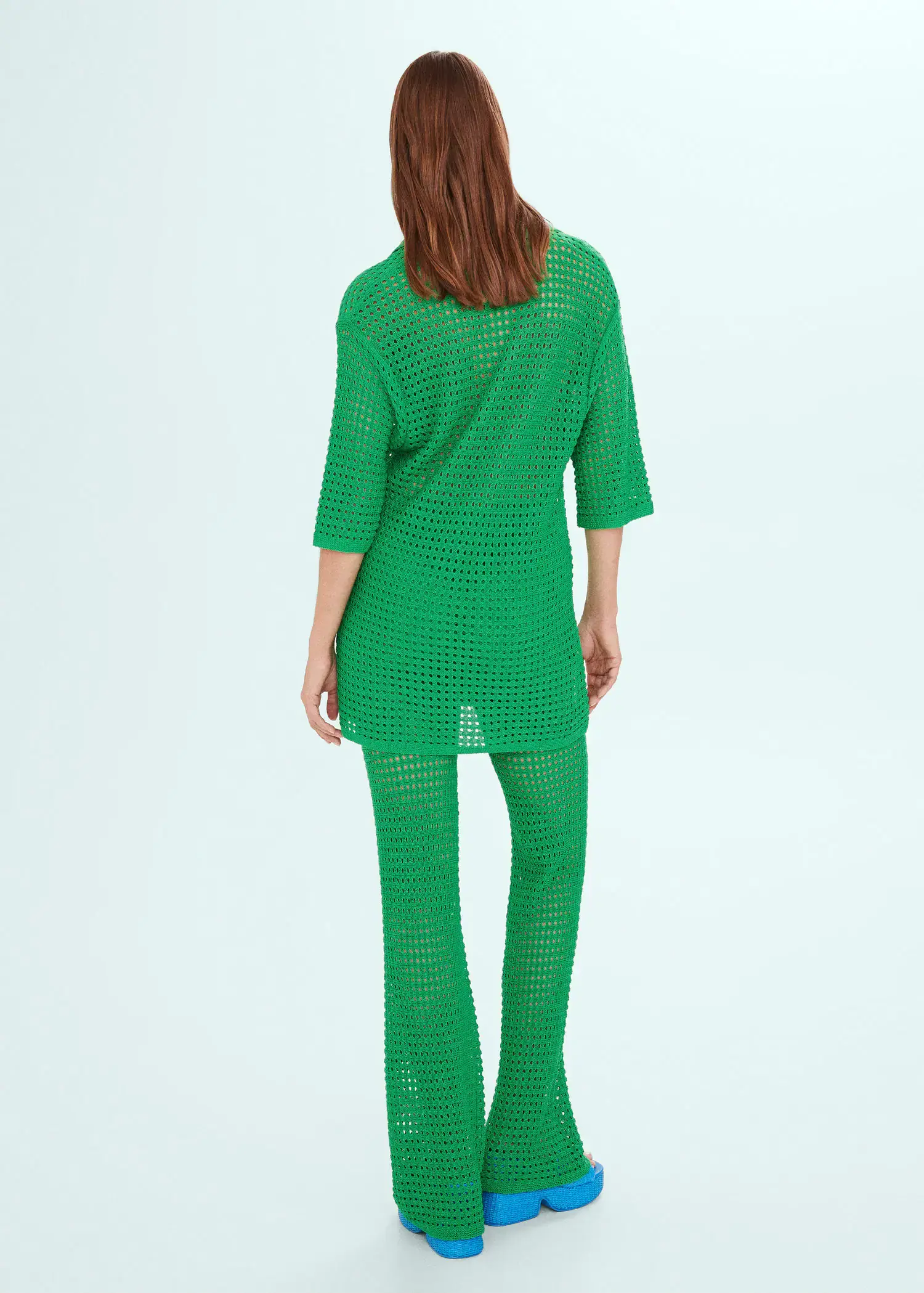 Mango Oversized openwork knitted polo shirt. a person wearing a green outfit standing in front of a wall. 