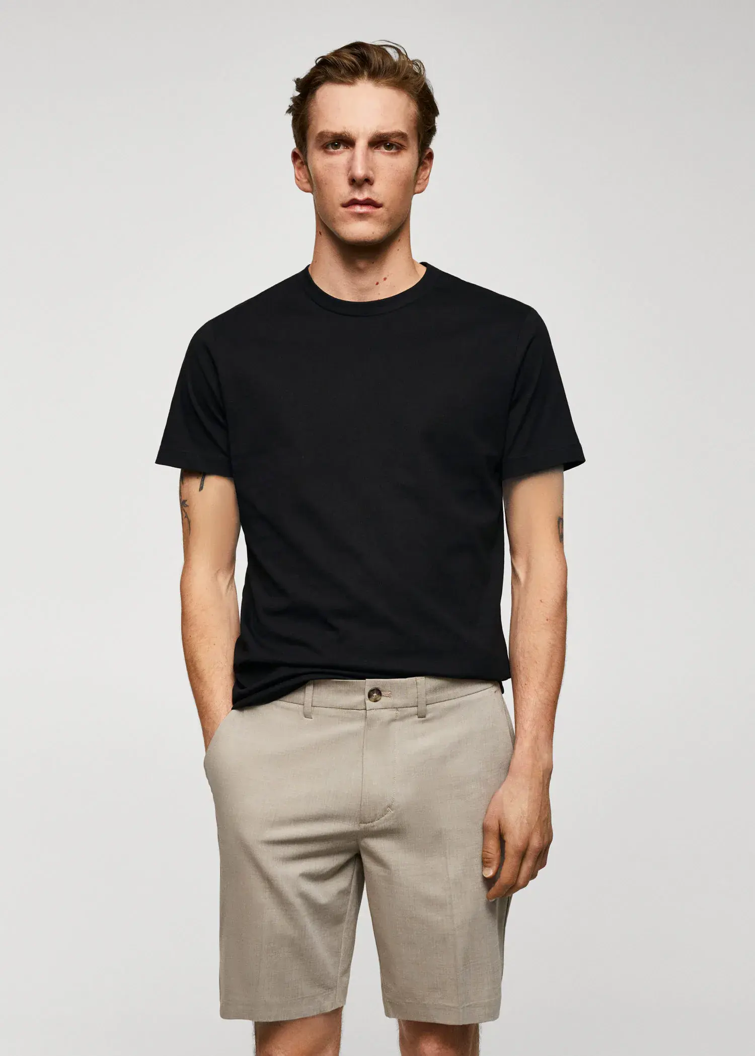 Mango Basic cotton stretch T-shirt. a man wearing a black shirt and beige pants. 