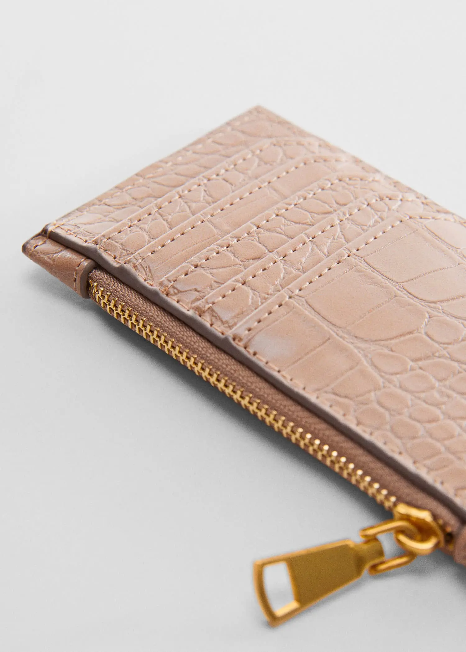 Mango Crocodile purse with logo. a close-up of the zipper of a wallet. 