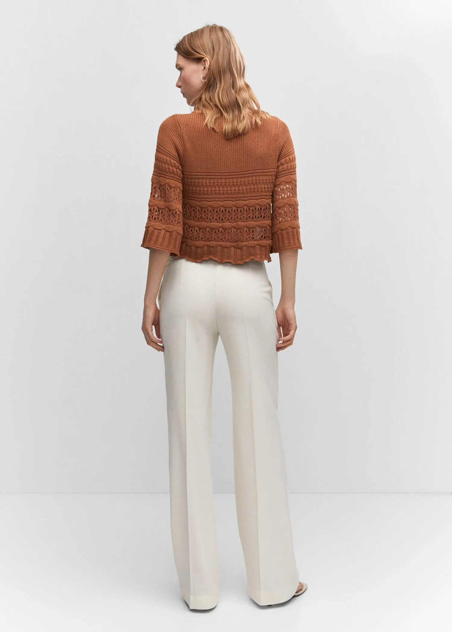 Mango Openwork sweater with flared sleeves. a woman wearing a brown sweater and white pants. 
