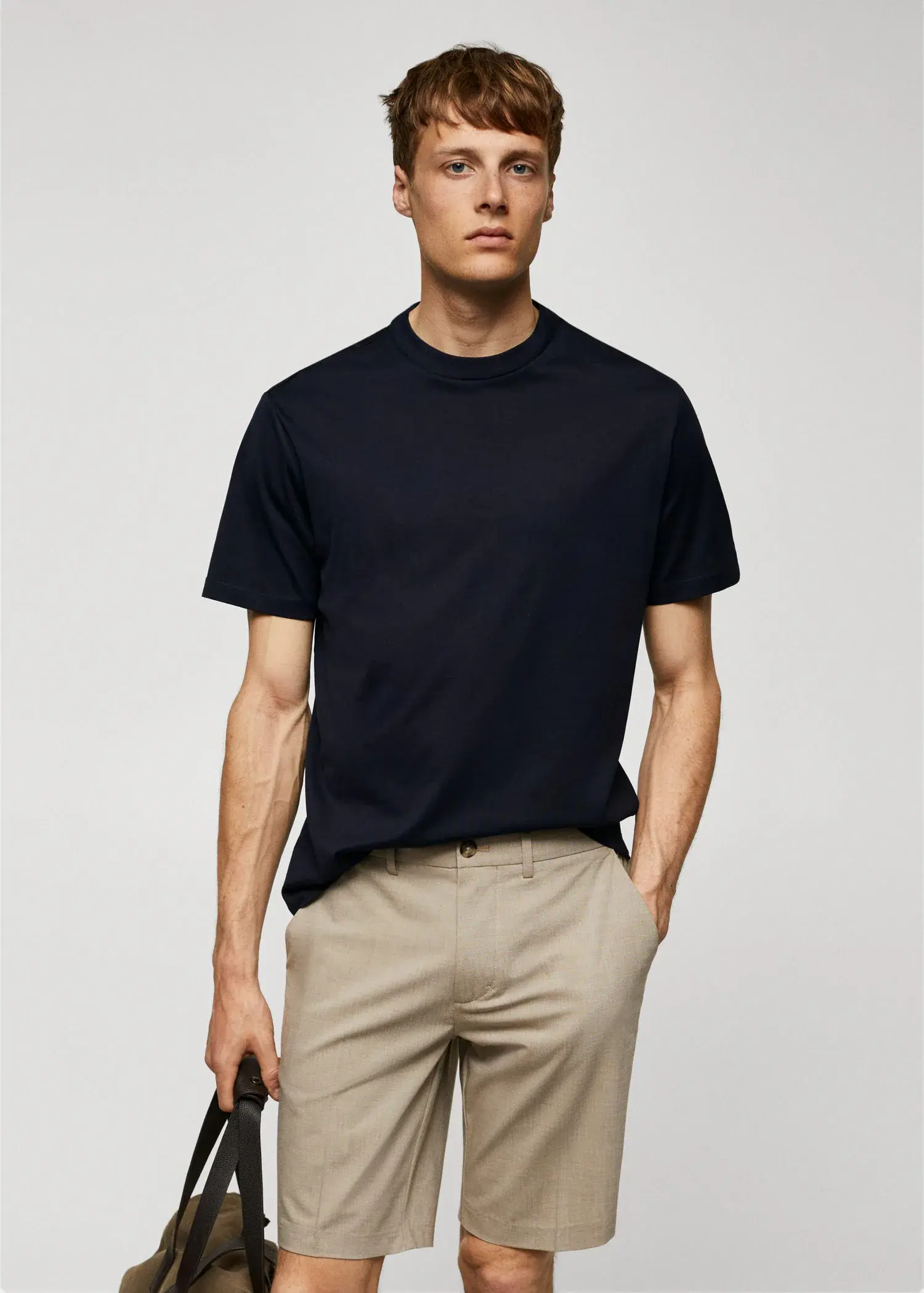 Mango Mercerized regular-fit t-shirt. a man wearing a black shirt and beige pants. 