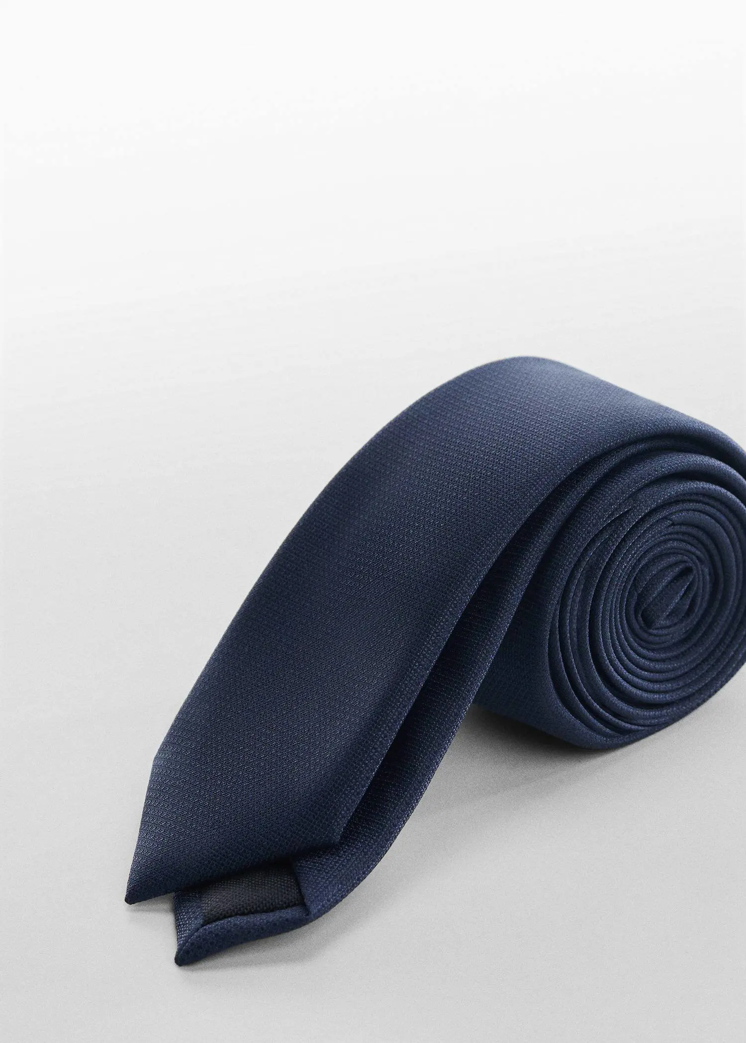 Mango Narrow structured tie. a close-up of a blue neck tie on a white surface. 