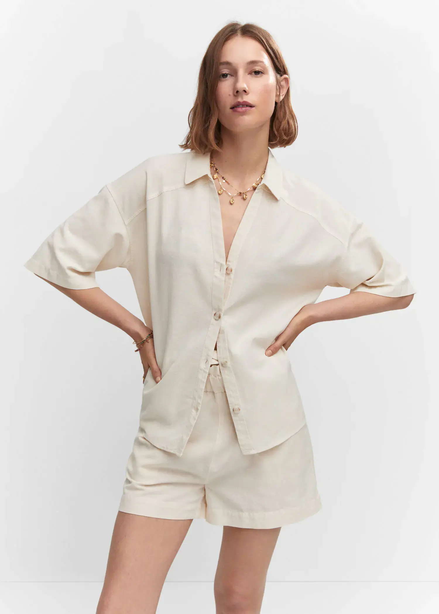 Mango Cotton linen-blend shirt. a woman in a white shirt and shorts. 