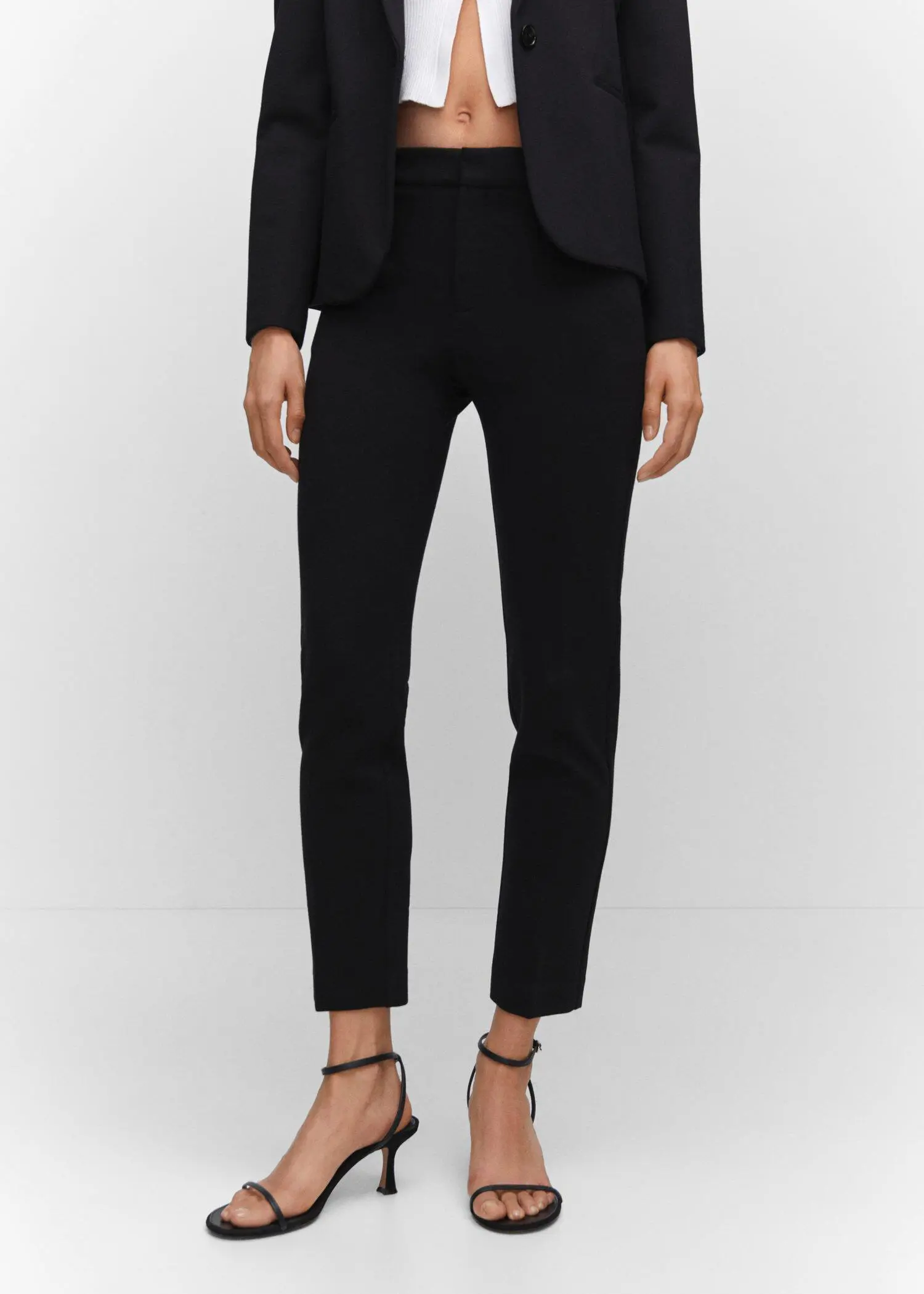 Mango Rome-knit straight pants. a woman wearing black pants and a black jacket. 