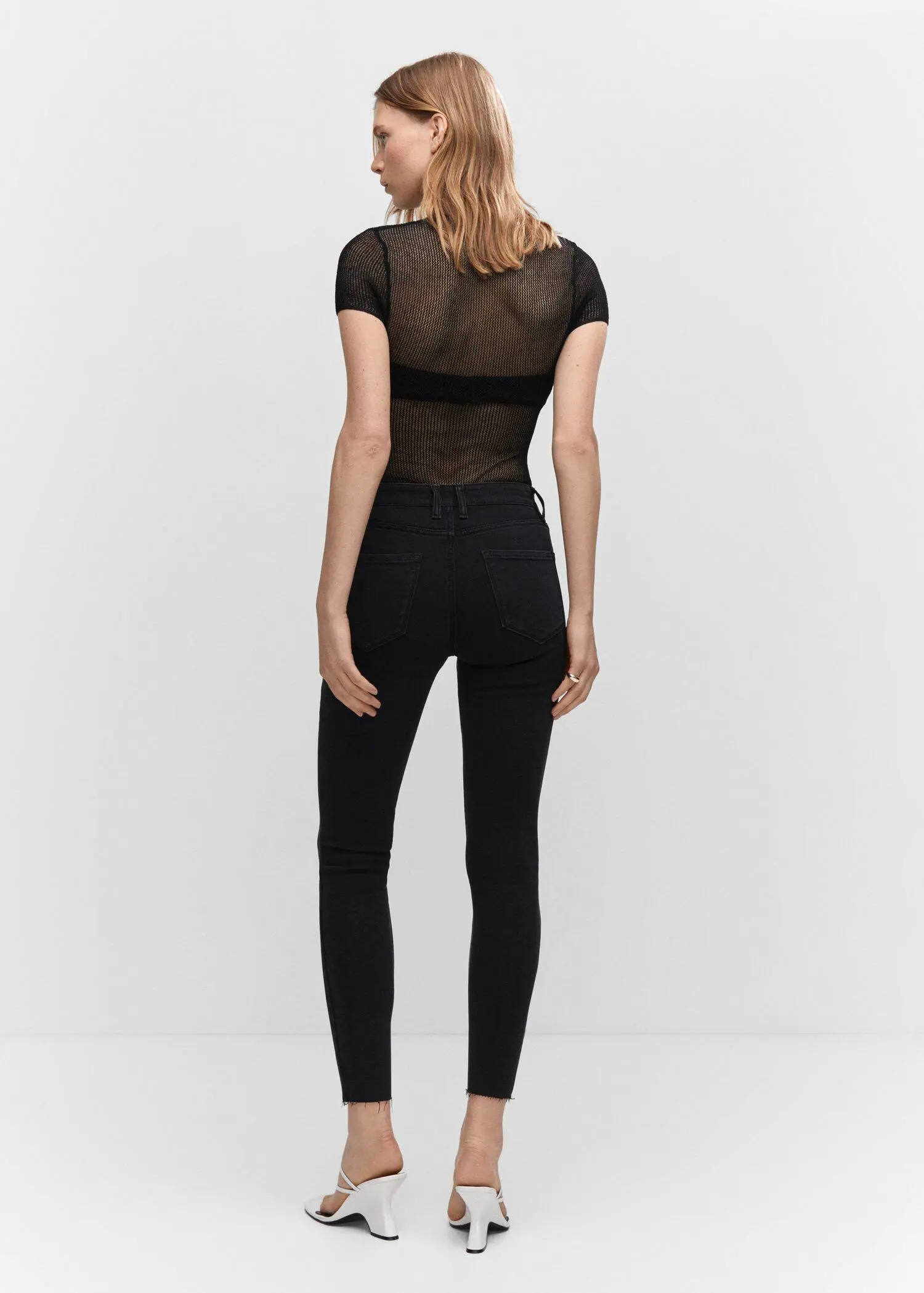 Mango Skinny cropped jeans. a woman wearing black pants and a black top. 