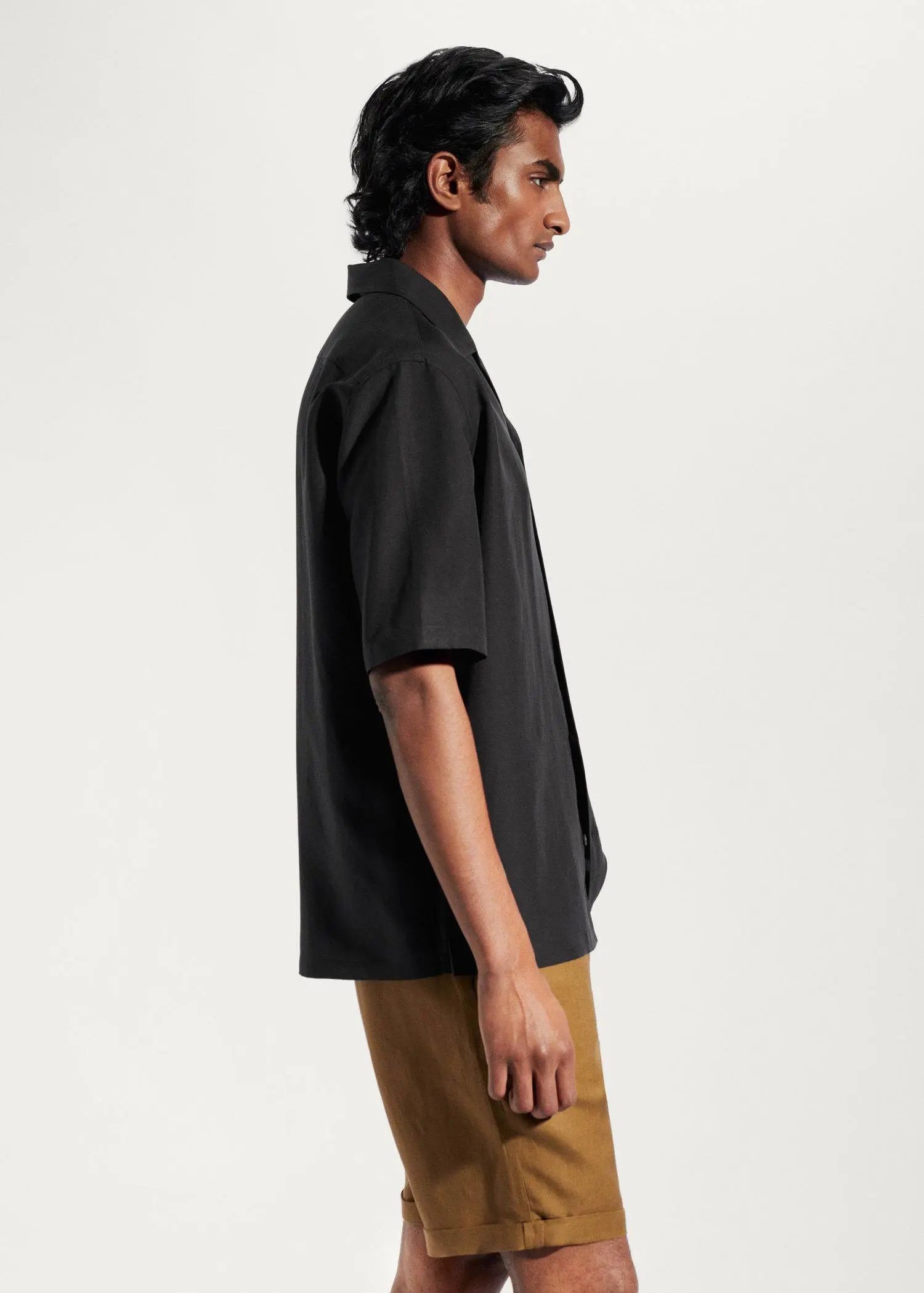 Mango Regular-fit linen bowling shirt. a man wearing a black shirt and brown pants. 